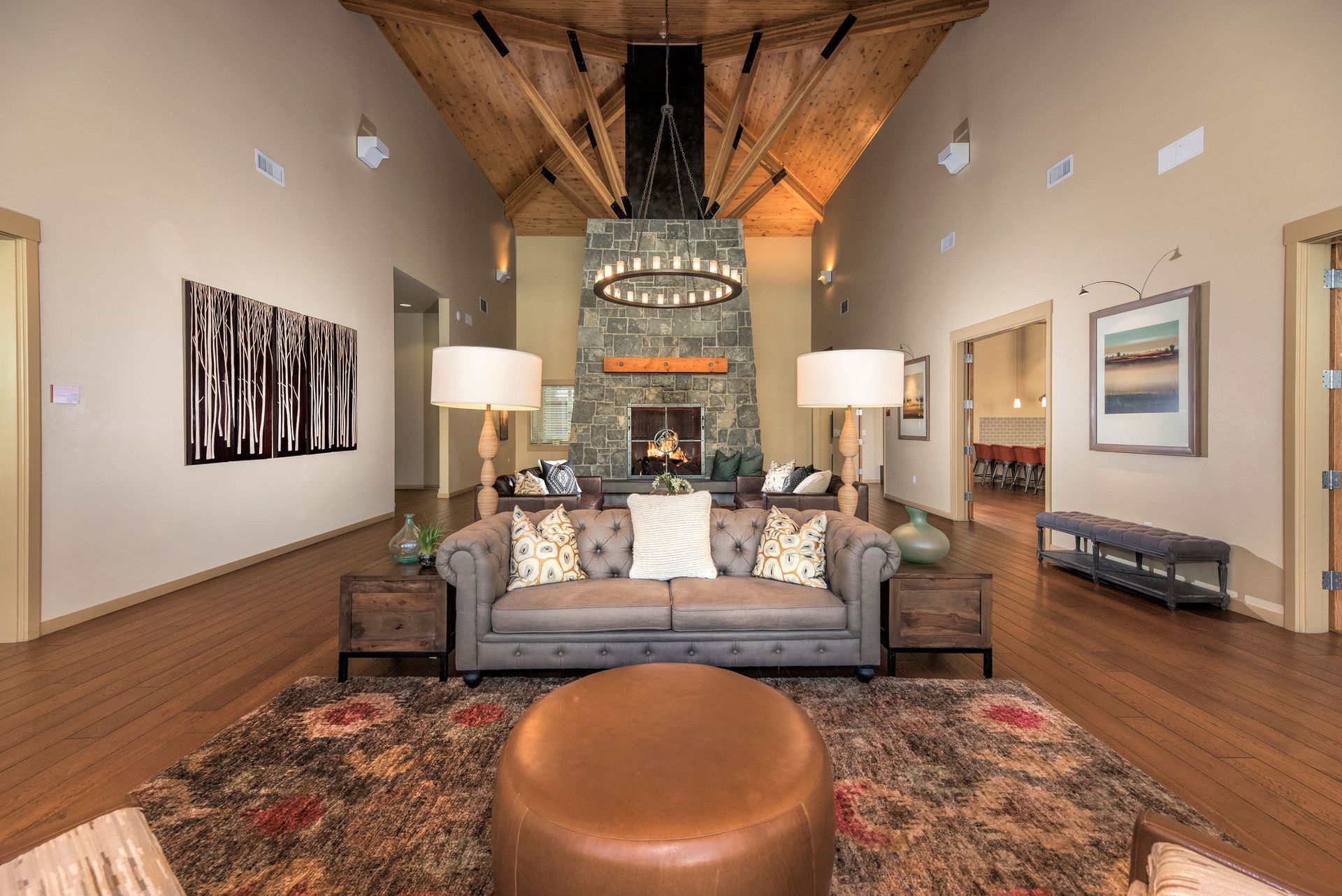 Spacious resident lounge with a stone fireplace, vaulted wooden ceiling, and seating area.
