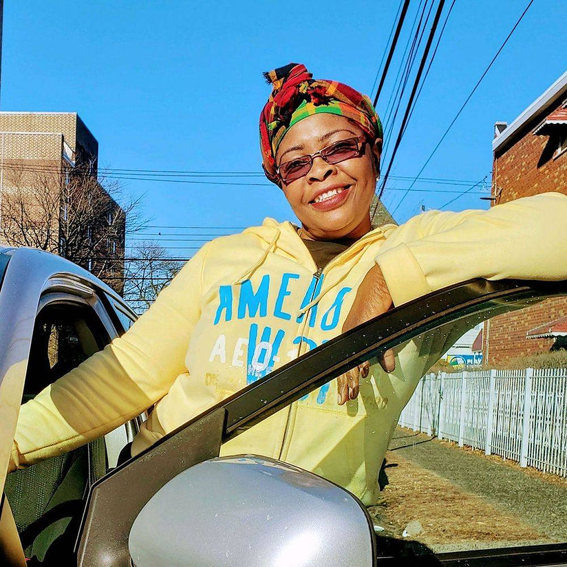 A woman wearing a yellow aeropostale sweatshirt leans out of a car window