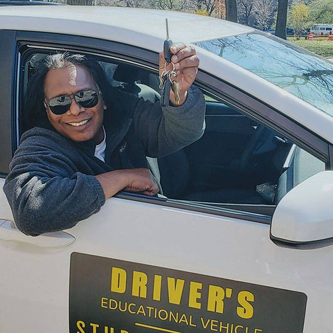 A man in a driver 's educational vehicle holding a key