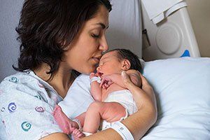 Woman Kissing a New Born Baby  — Gynecology in Monterey,CA