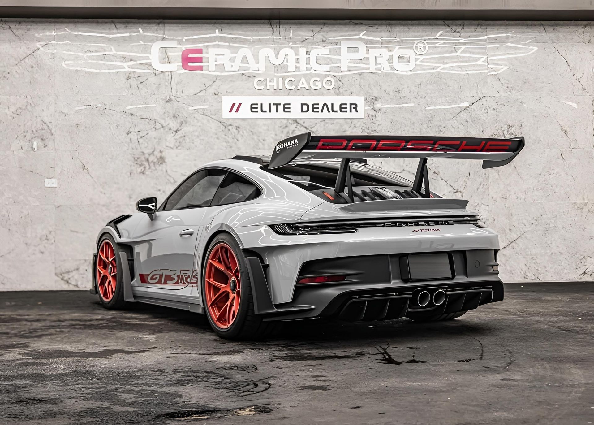 Grey Porsche 911 GT3 with orange wheels and spoiler, Ceramic Pro Chicago Elite Dealer background.