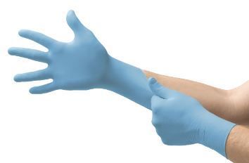 Una persona se pone un par de guantes azules.