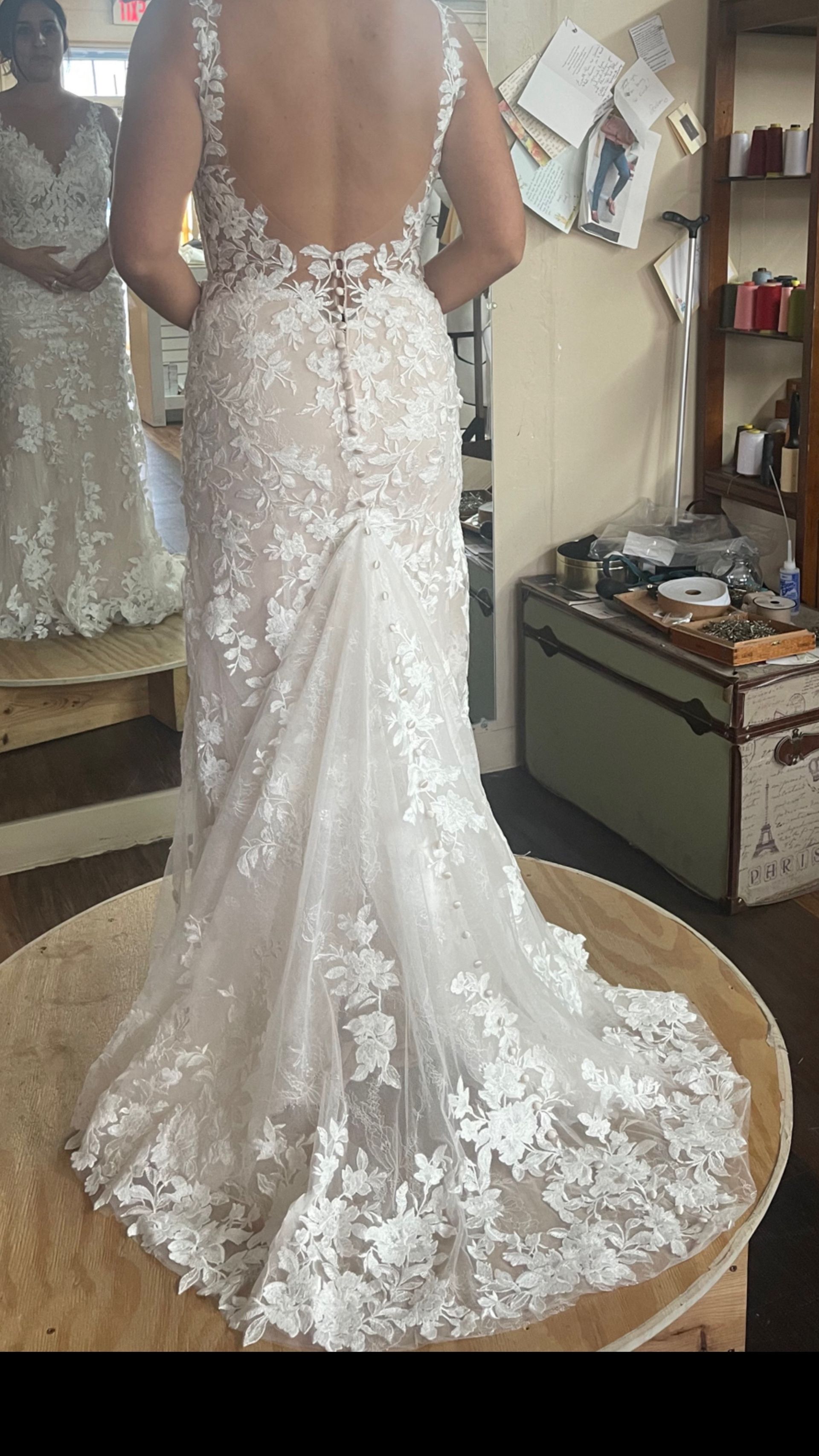 The back of a woman wearing a wedding dress is shown.