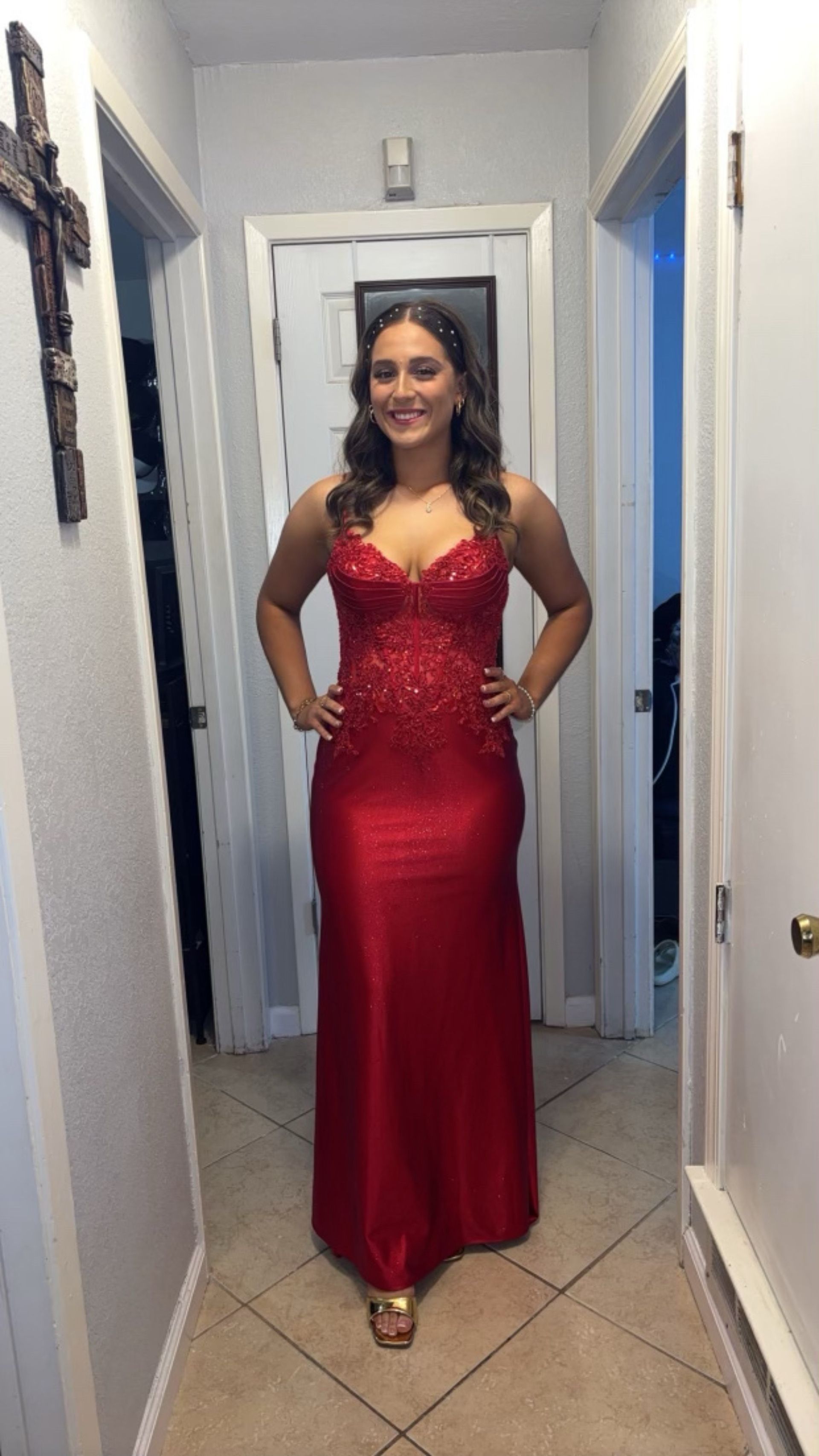 A woman in a red dress is standing in a hallway.