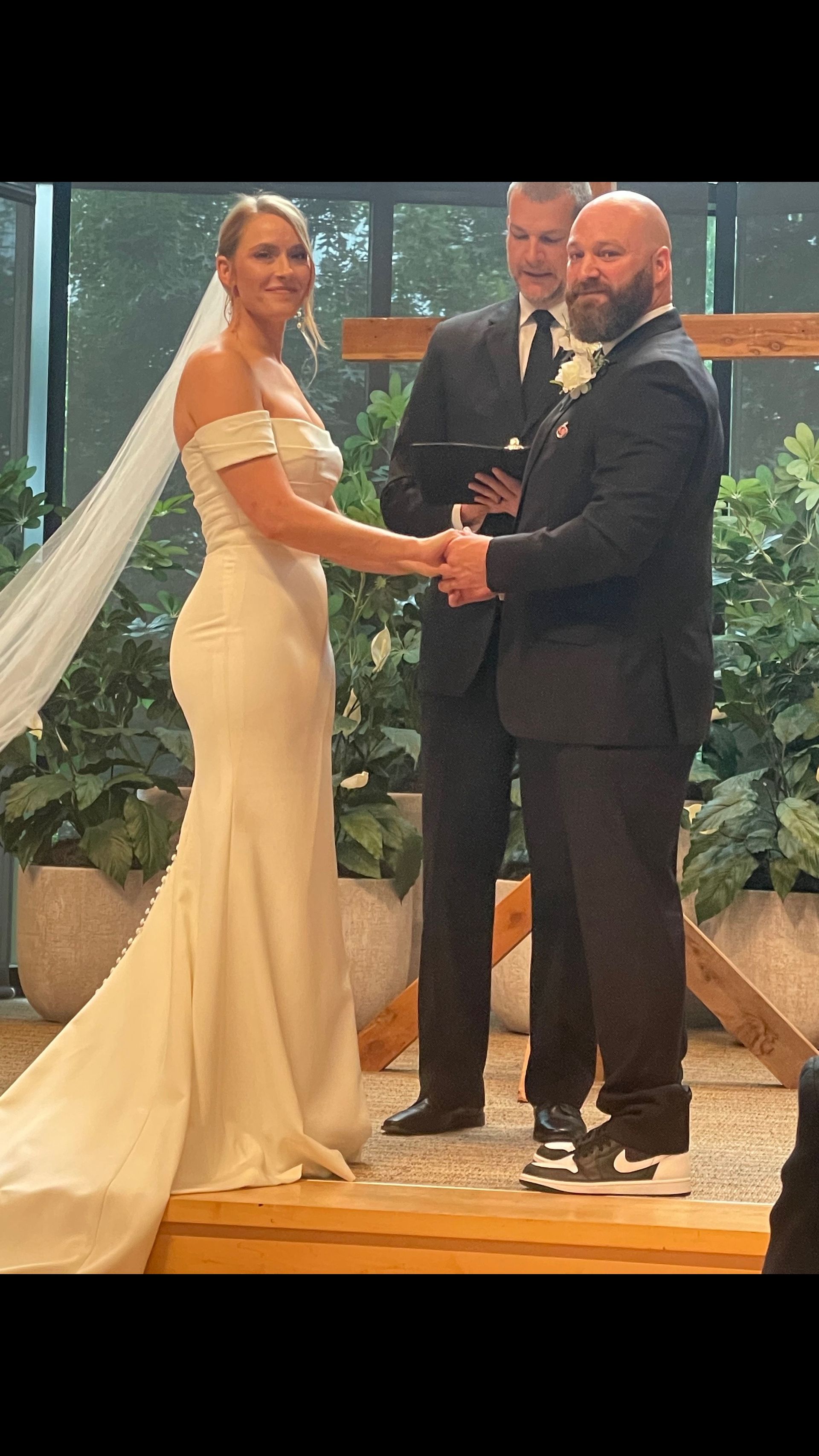 A bride and groom are holding hands during their wedding ceremony.