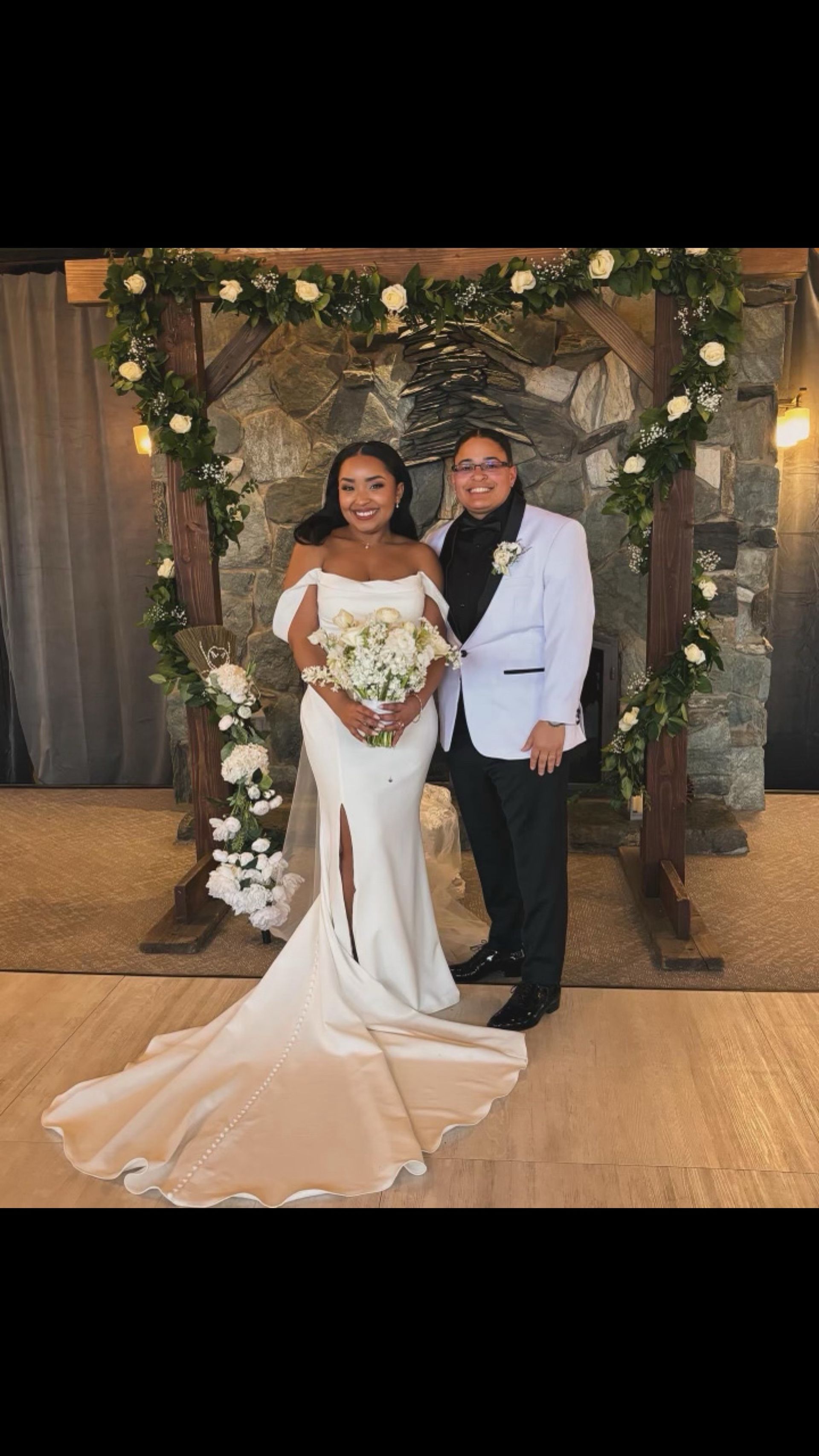 A bride and groom are posing for a picture at their wedding.