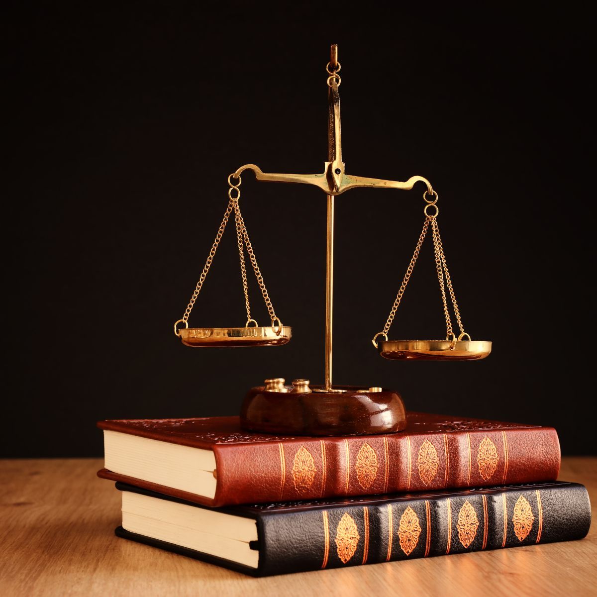 A scale of justice sits on top of a stack of books