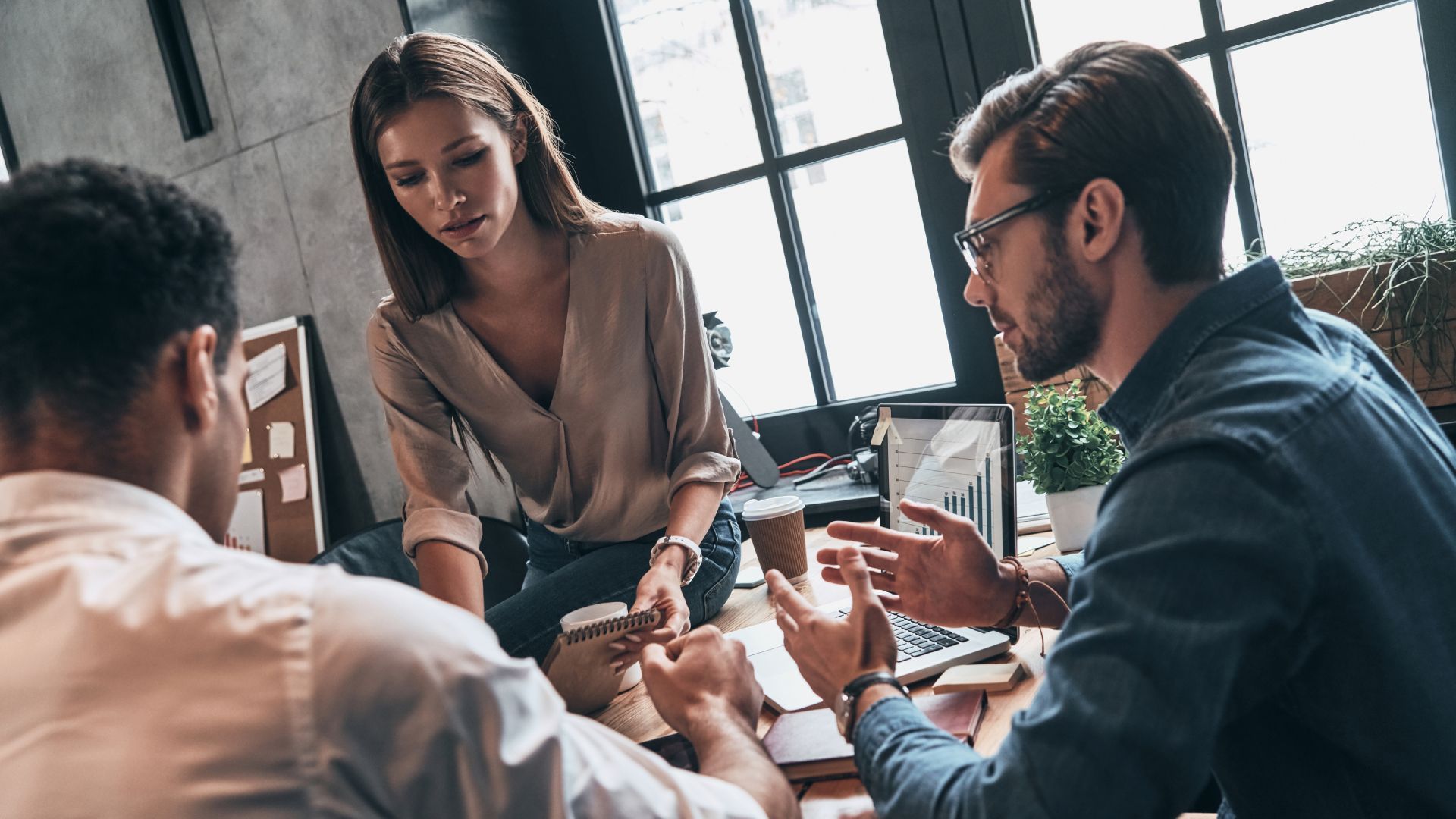 A group of people are sitting around a table having a meeting.