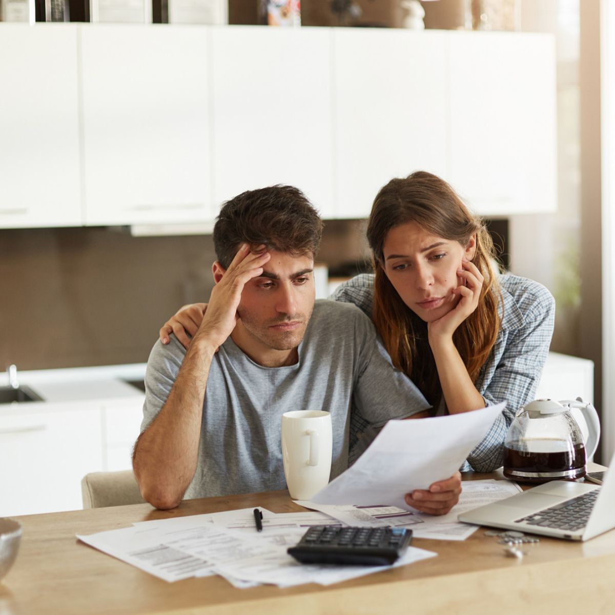 A man and a woman are sitting at a table looking at a piece of paper.