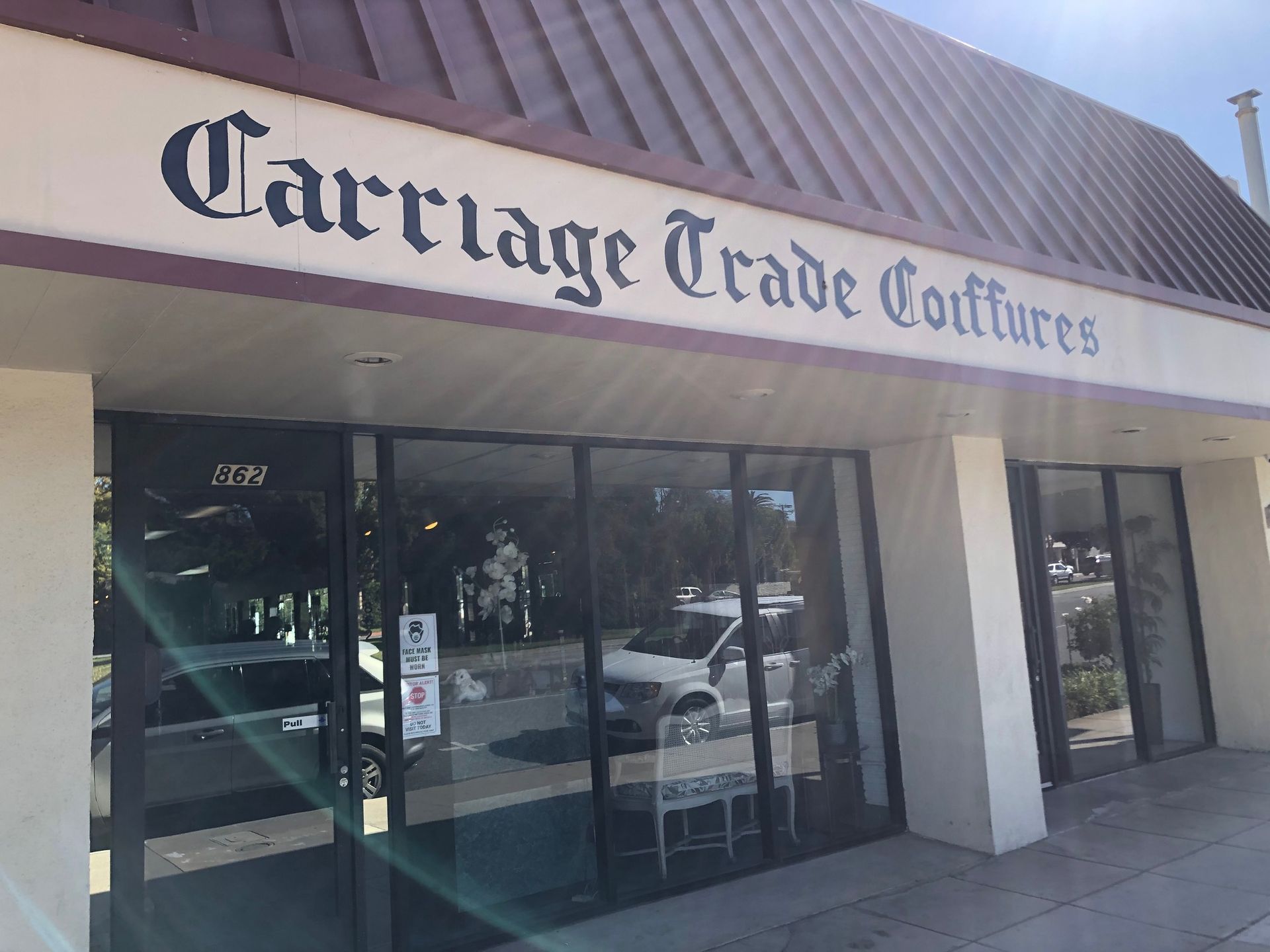 Hairdresser cutting dark hair with scissors and comb in a salon.