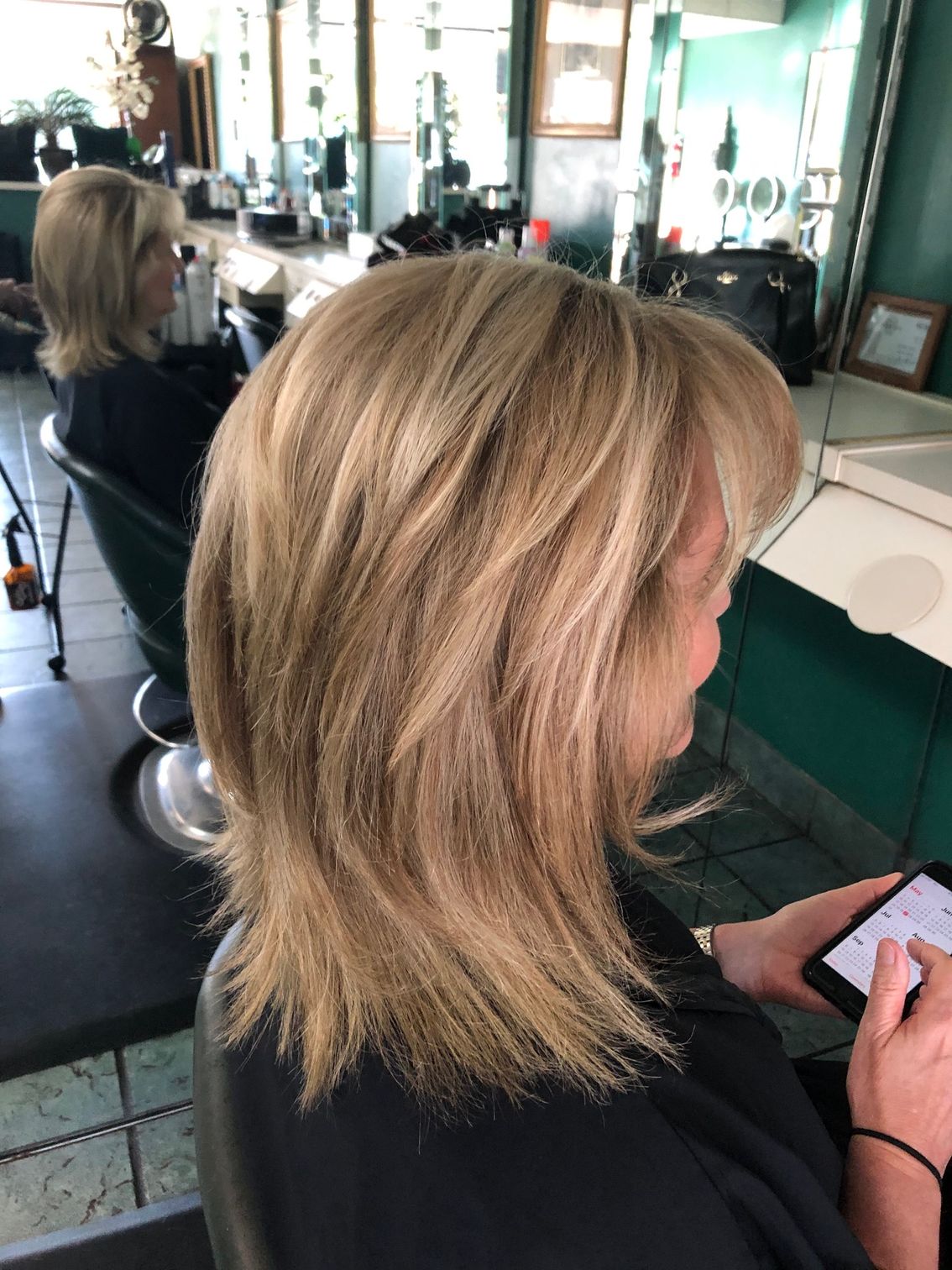 Woman getting hair washed with foamy product at a salon.