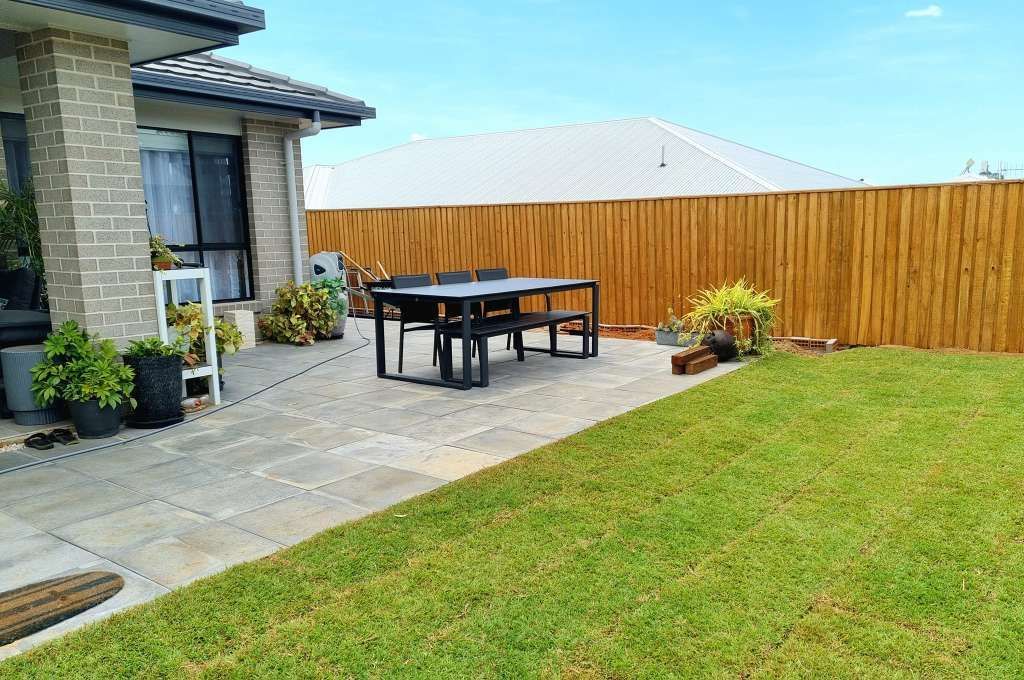 Backyard Patio With Table, Bench, Grass, and Wooden Fence — On The Mark Landscaping in Branyan, QLD