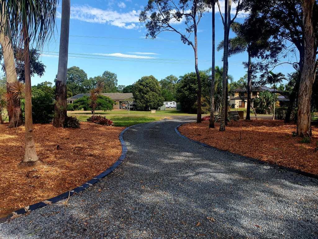 Gravel Driveway Winds Through a Landscape With Mulch, Trees, and Houses — On The Mark Landscaping in Innes Park, QLD
