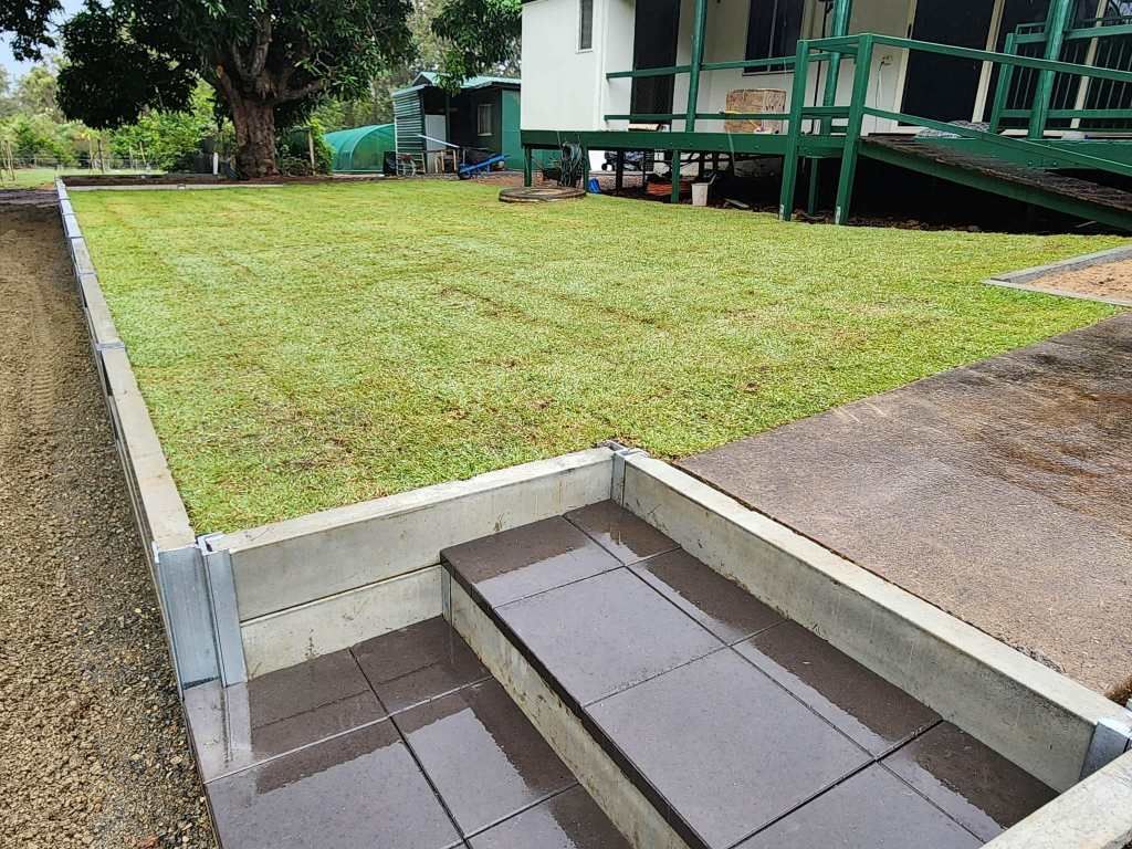 Concrete Steps Lead Up to a Well-manicured Lawn in Front of a House With Green Trim — On The Mark Landscaping in Branyan, QLD