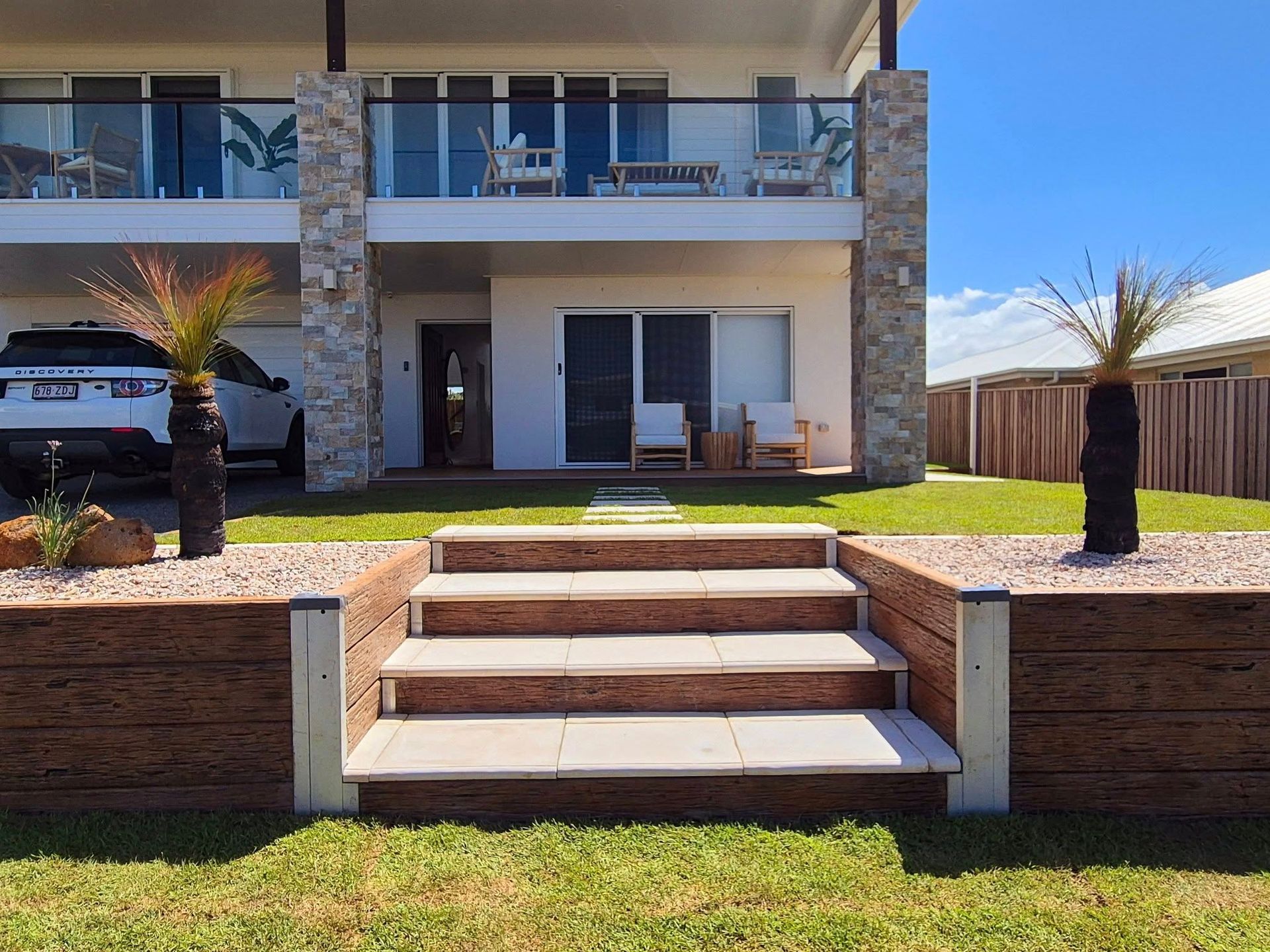 Front View of a  Modern House With Stone Accents, Steps Leading to the Entrance — On The Mark Landscaping in Branyan, QLD