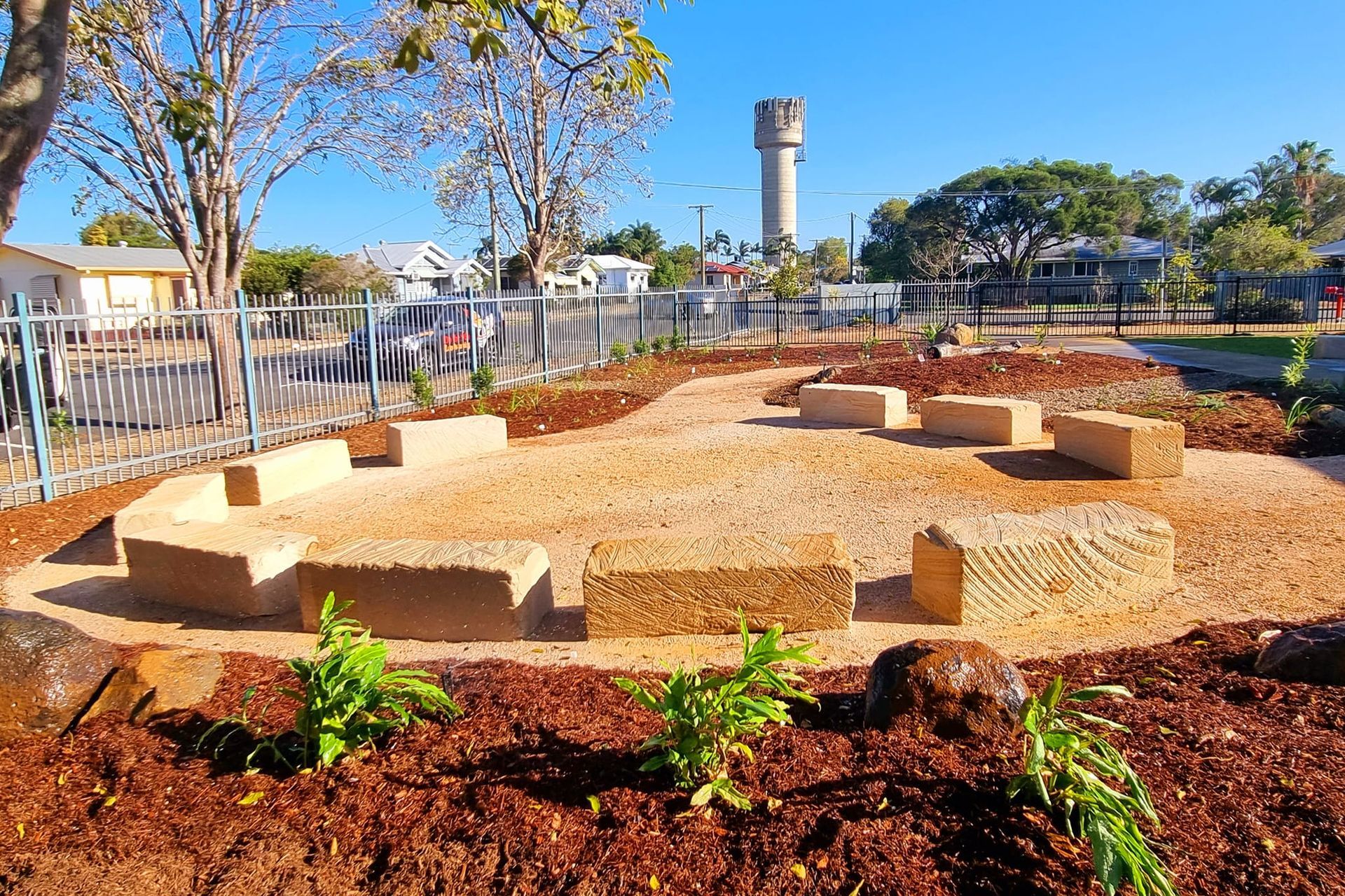 An Outdoor Seating Area With Stone Benches in a Circular Layout — On The Mark Landscaping in Branyan, QLD