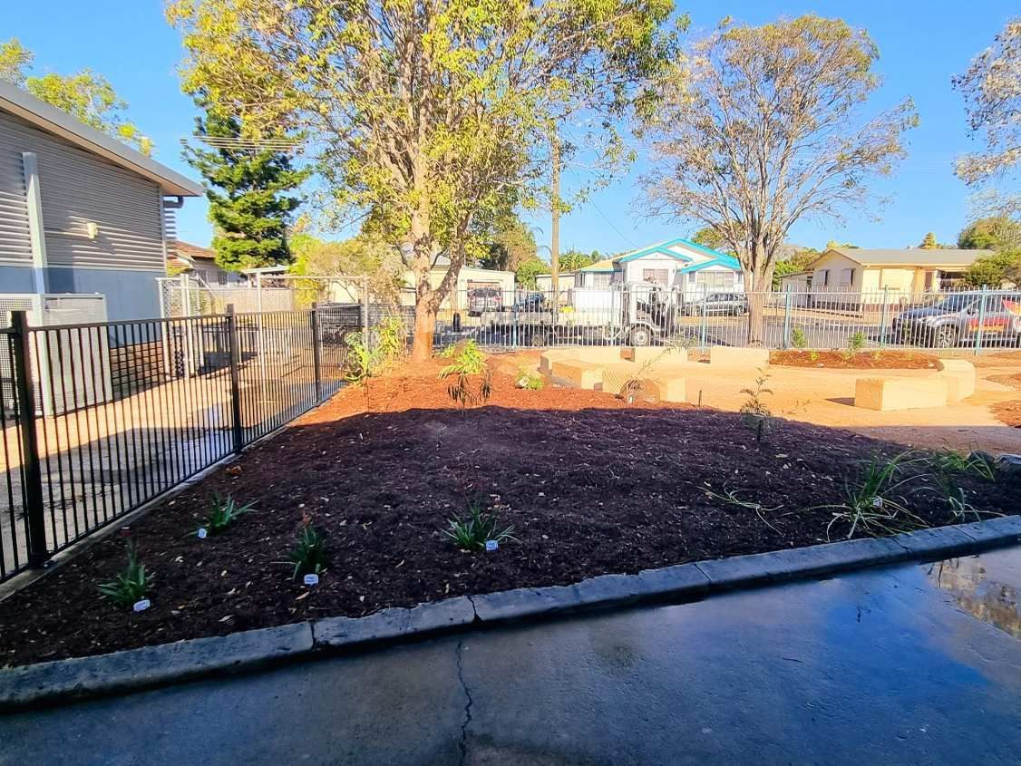 Landscaped Bed With Mulch, Plants, Trees, and a Decorative Fence — On The Mark Landscaping in Elliot Heads, QLD