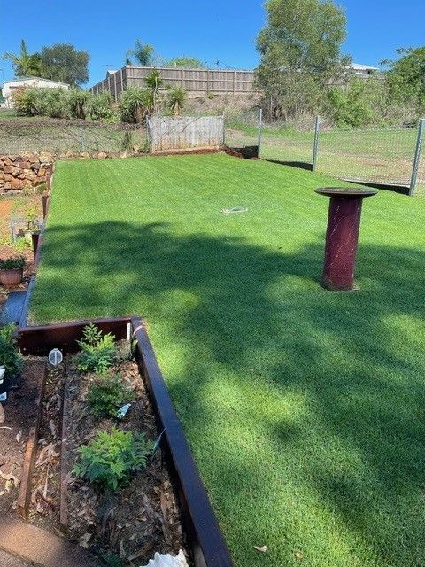 Well-manicured Green Lawn With a Raised Garden Bed, a Tall Table, and a Fence — On The Mark Landscaping in Branyan, QLD