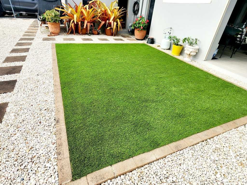 Artificial Grass Lawn Bordered by Gravel, Stone Pavers, and Plants — On The Mark Landscaping in Branyan, QLD