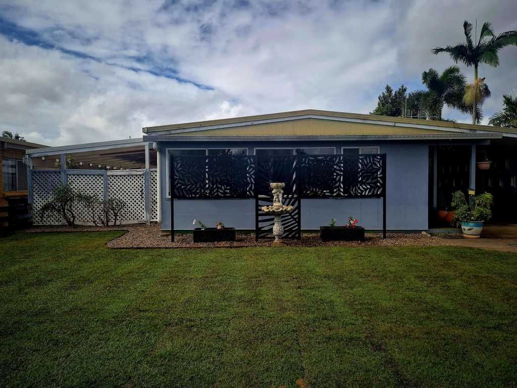 Blue House With Lattice Fence, Decorative Screen, and Grass Lawn — On The Mark Landscaping in Branyan, QLD