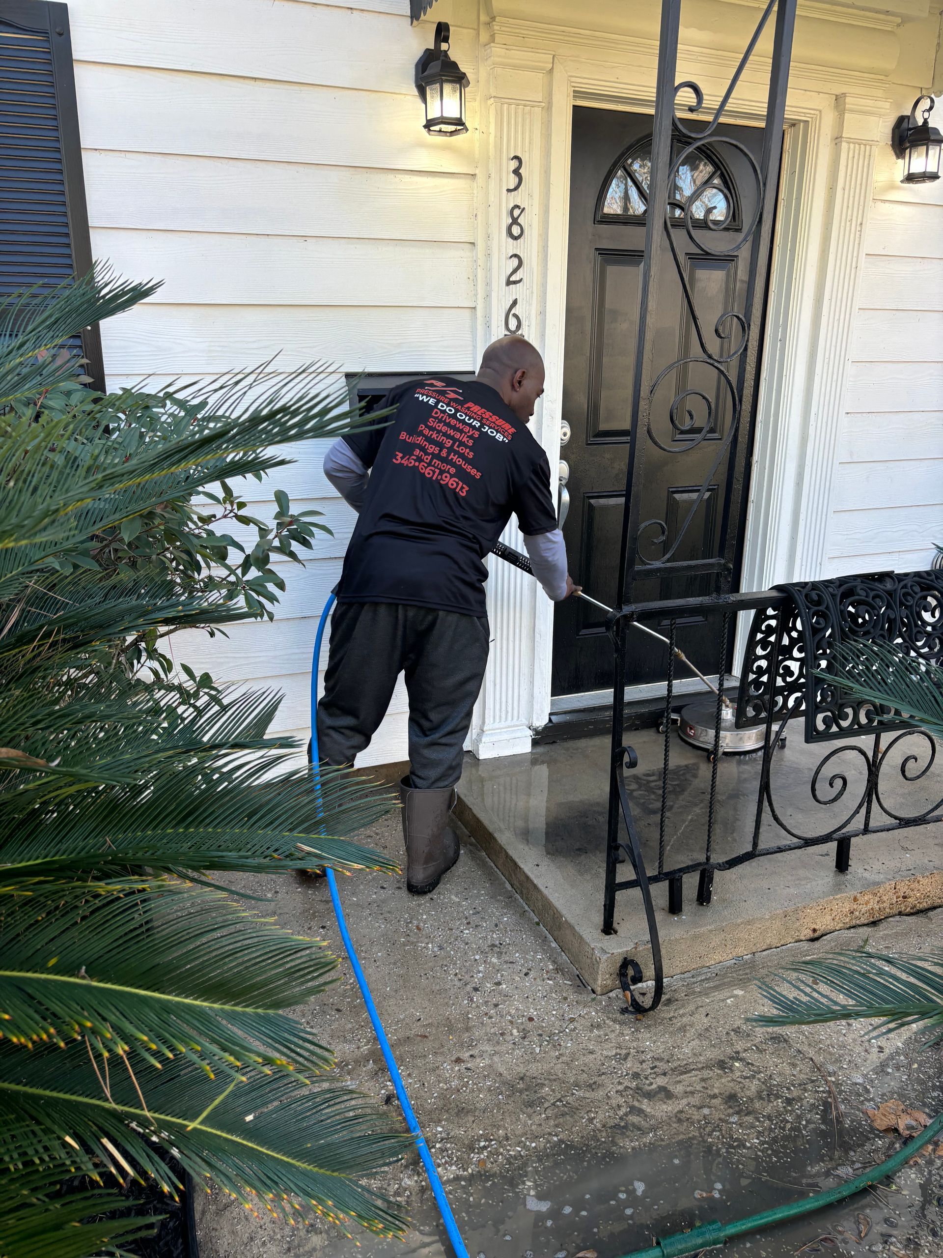 A person is cleaning a window with a high pressure washer.