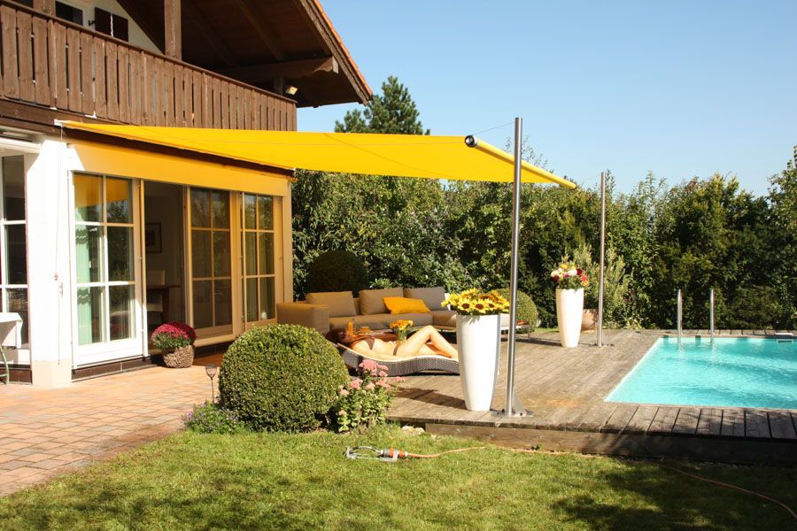 Ein Haus mit Swimmingpool und gelber Markise