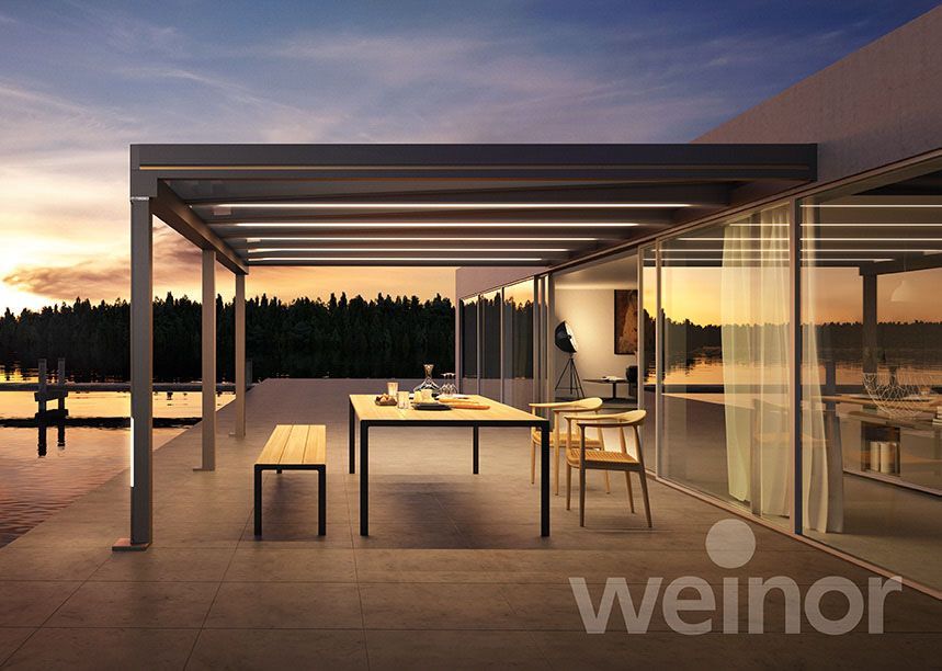 Eine Terrasse mit Tisch und Stühlen unter einer Pergola.