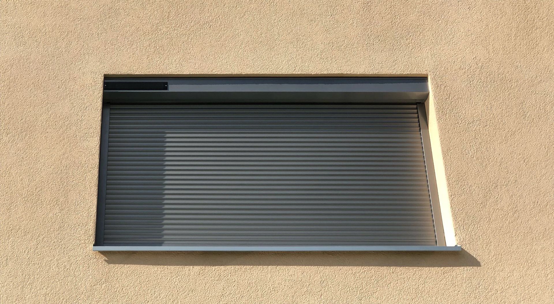 An der Seite eines Gebäudes befindet sich ein Fenster mit einem Fensterladen.