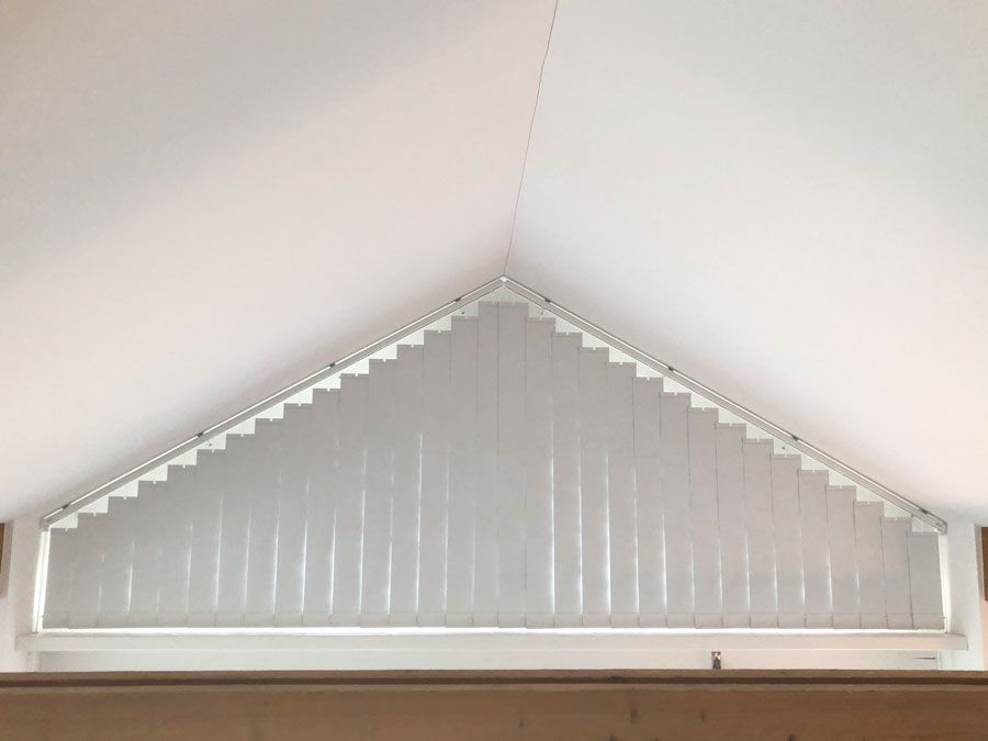 Ein Fenster mit einer dreieckigen Jalousie.