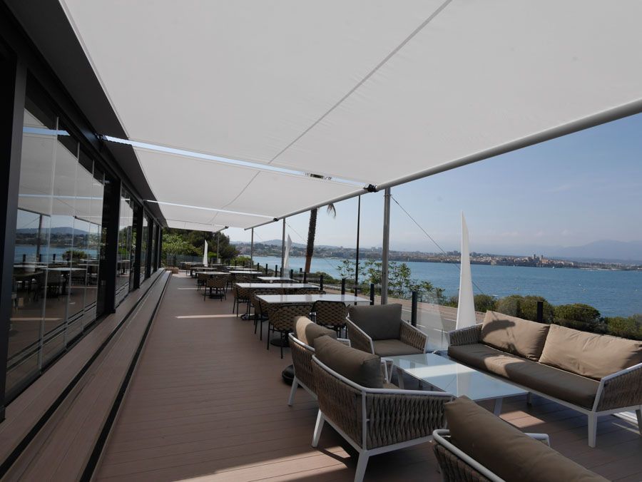 Eine Terrasse mit Blick auf das Meer und Tischen und Stühlen