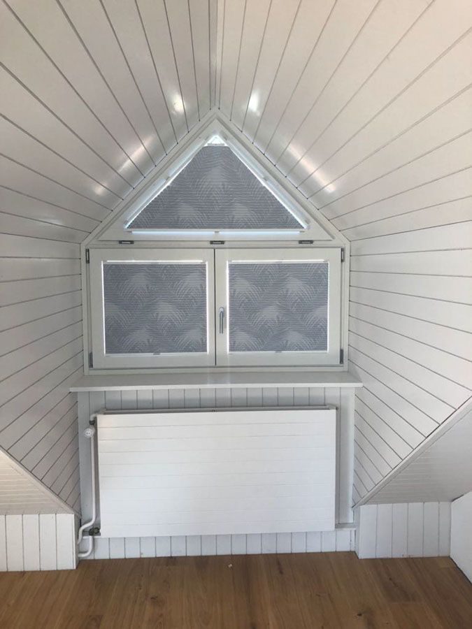 Ein Raum mit einem Fenster und einem Heizkörper darin