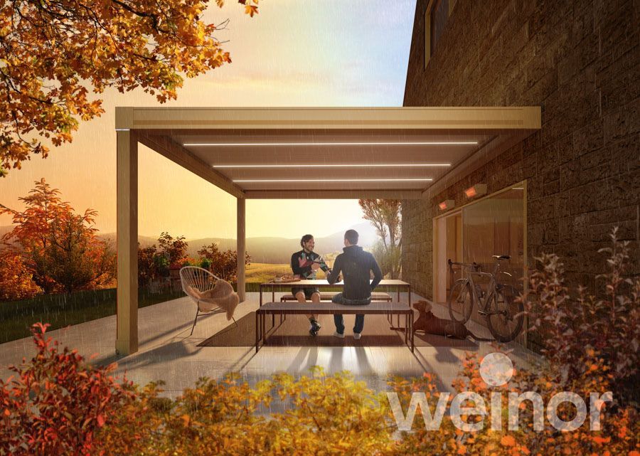 Ein paar Leute sitzen auf einer Bank unter einer Pergola.
