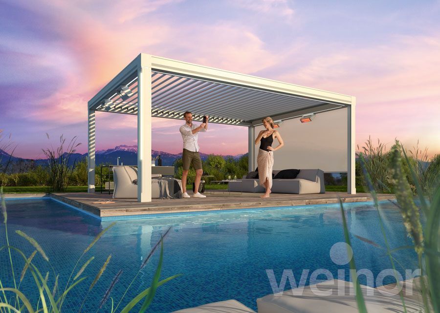 Ein Mann und eine Frau stehen unter einer Pergola neben einem Swimmingpool.