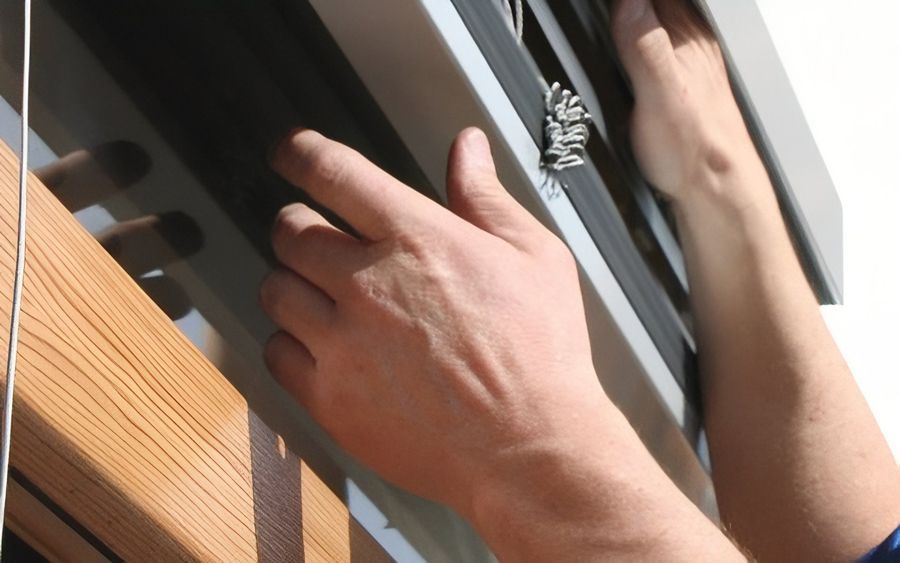 Nahaufnahme der Hände einer Person, die an einem Fenster arbeitet