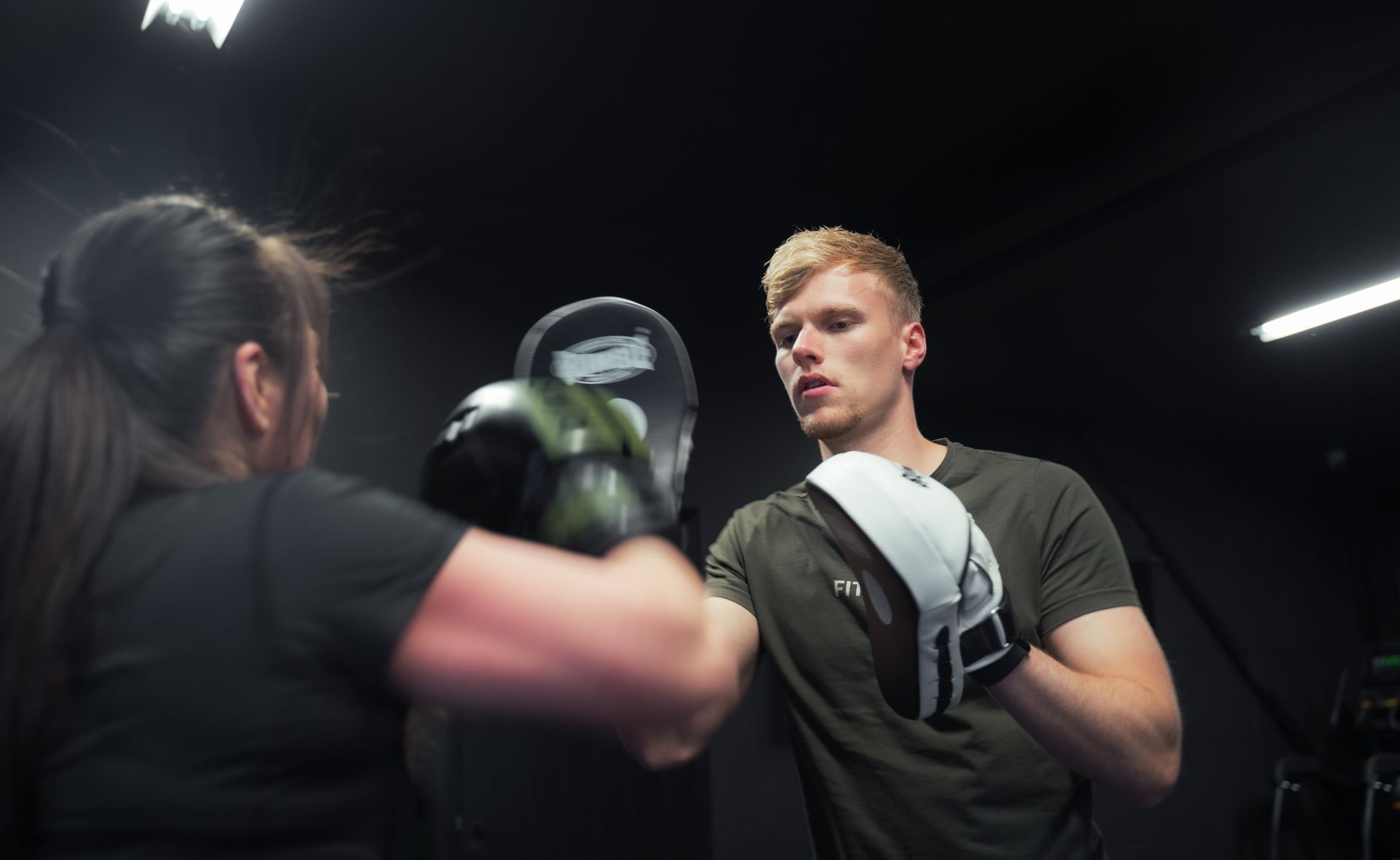 Een vrouw bokst met een personal trainer in een personal training studio.