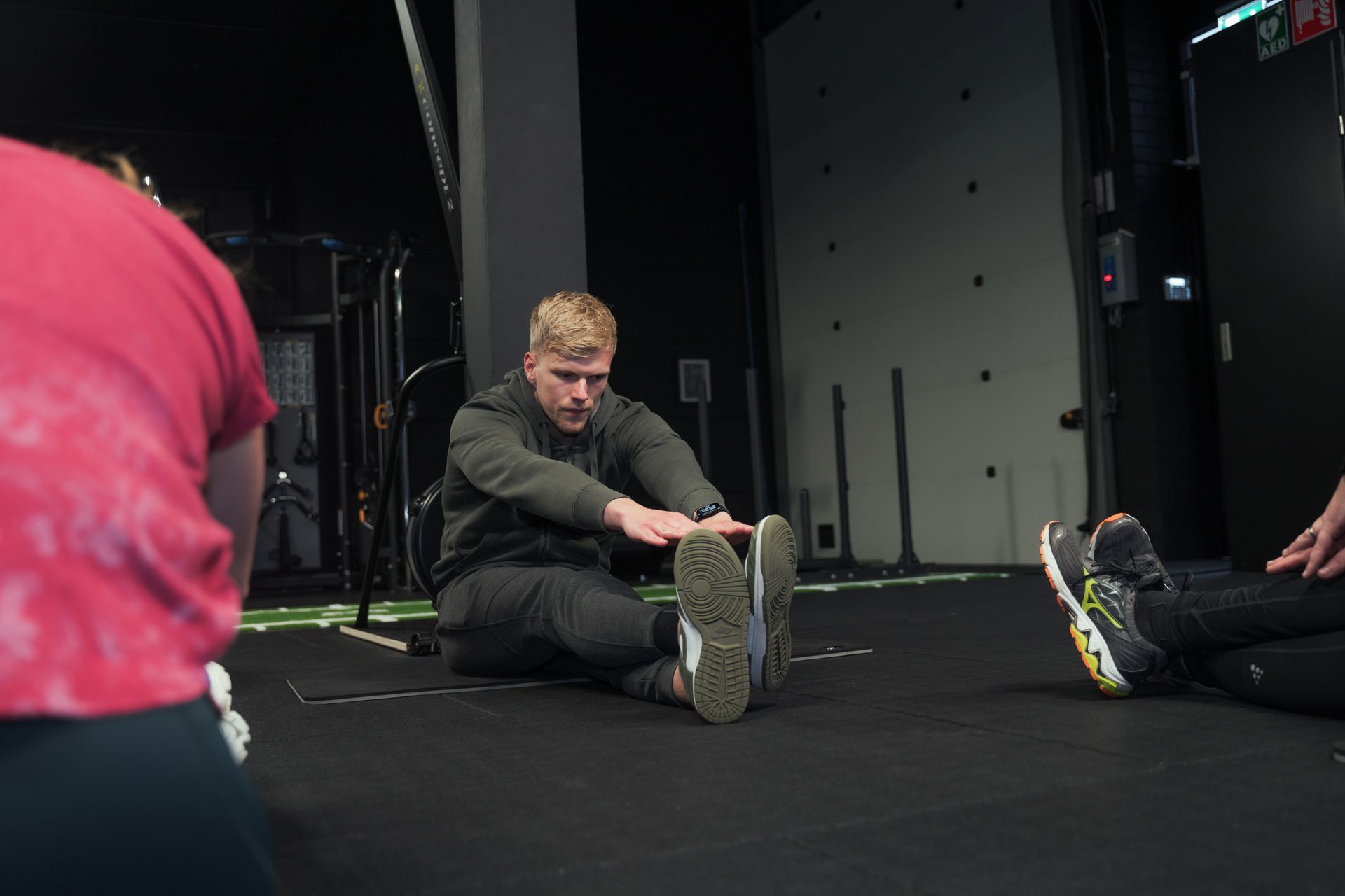 Een personal trainer doet stretchoefeningen voor in een personal training studio.