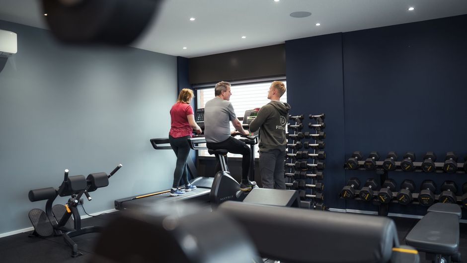 Een groep mensen zit aan een bar in een sportschool.