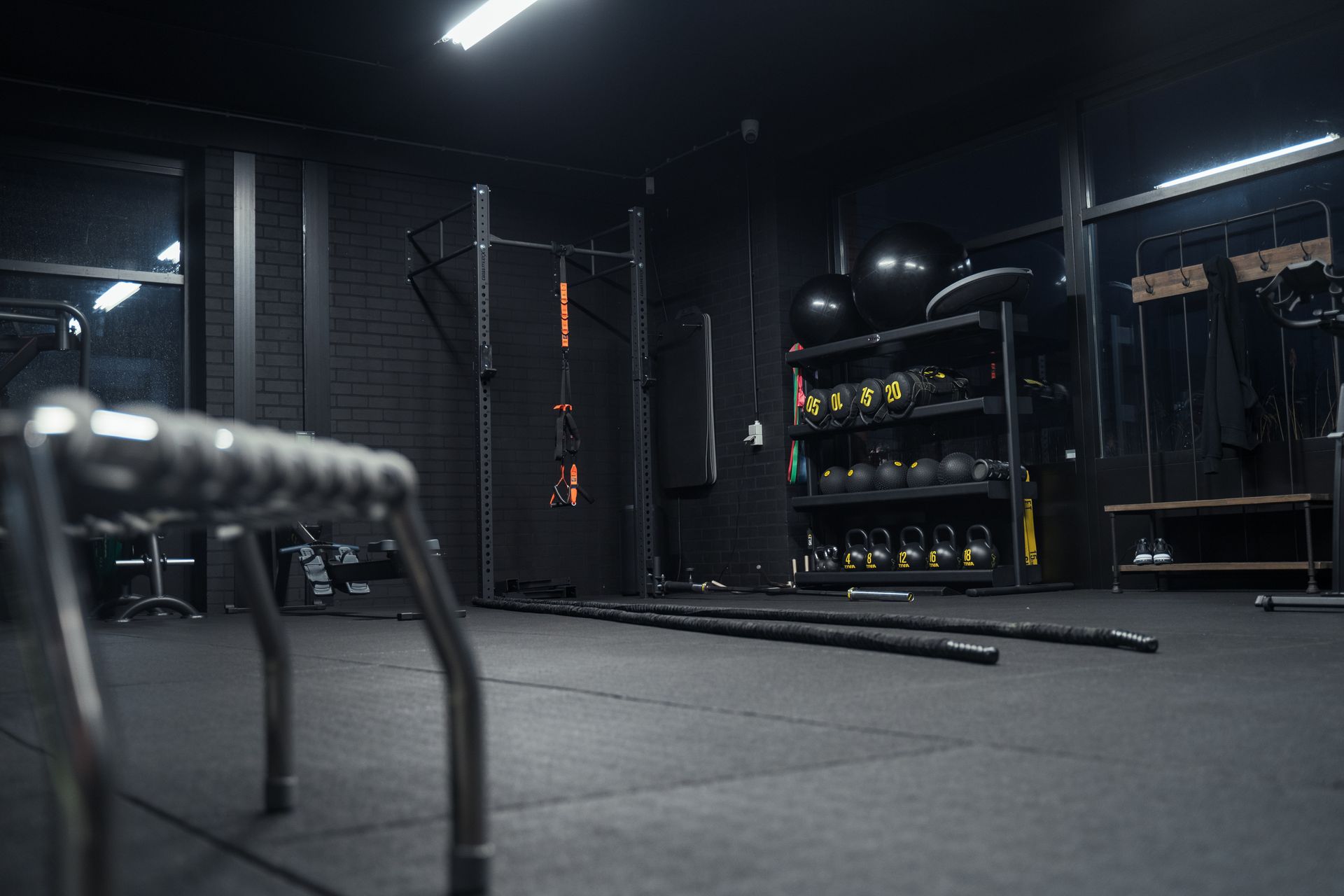 Een gymzaal met veel apparatuur en een stoel in het midden van de ruimte.
