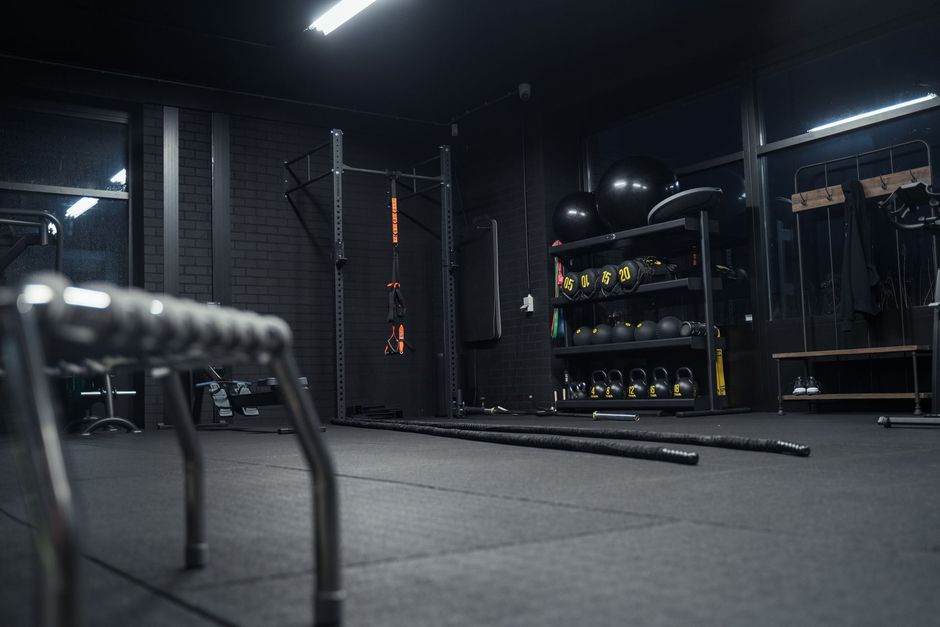 Een gymzaal met veel apparatuur en een stoel in het midden van de ruimte.
