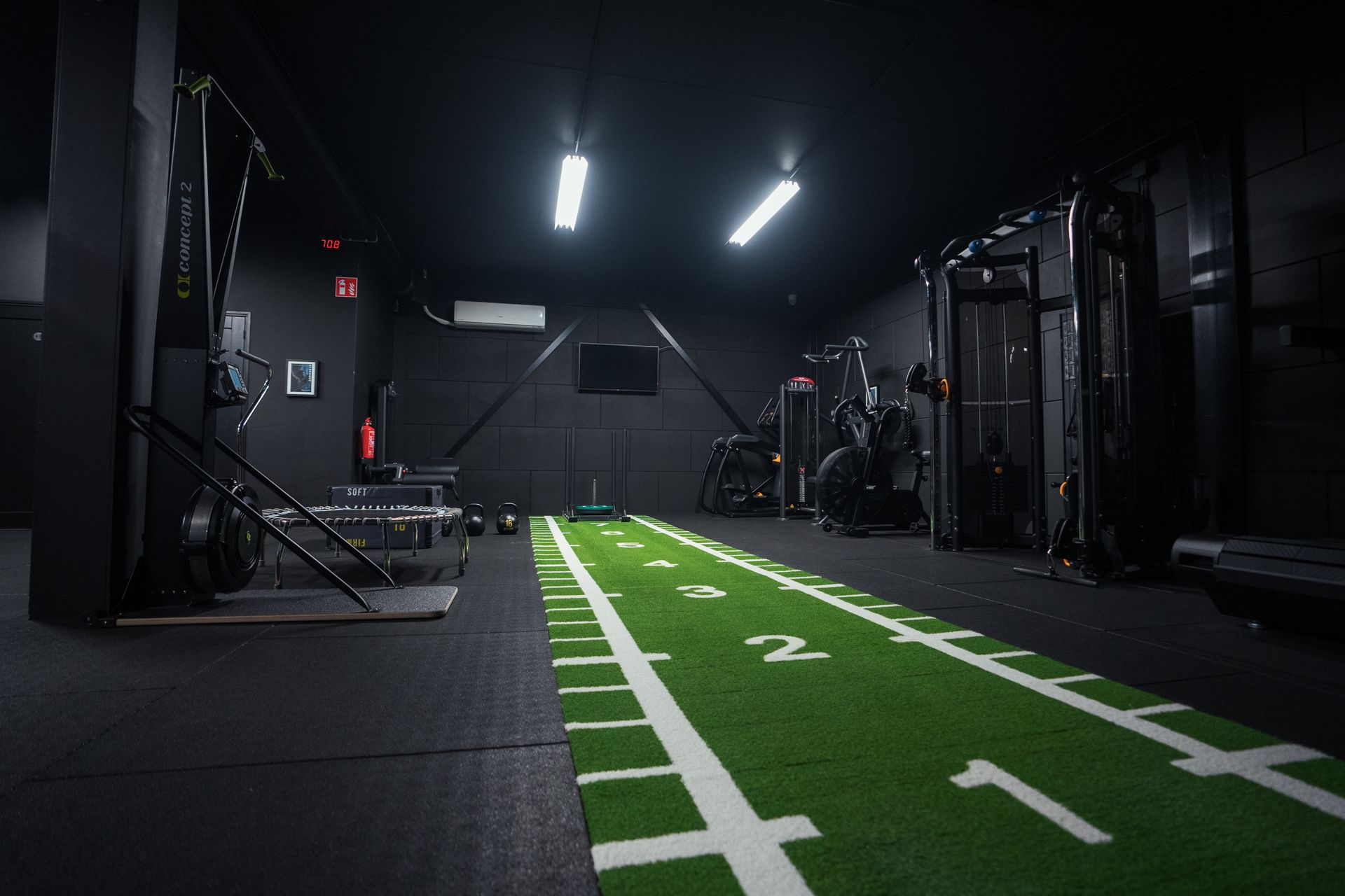 Een personal training studio met een groen veld en een witte lijn op de vloer.
