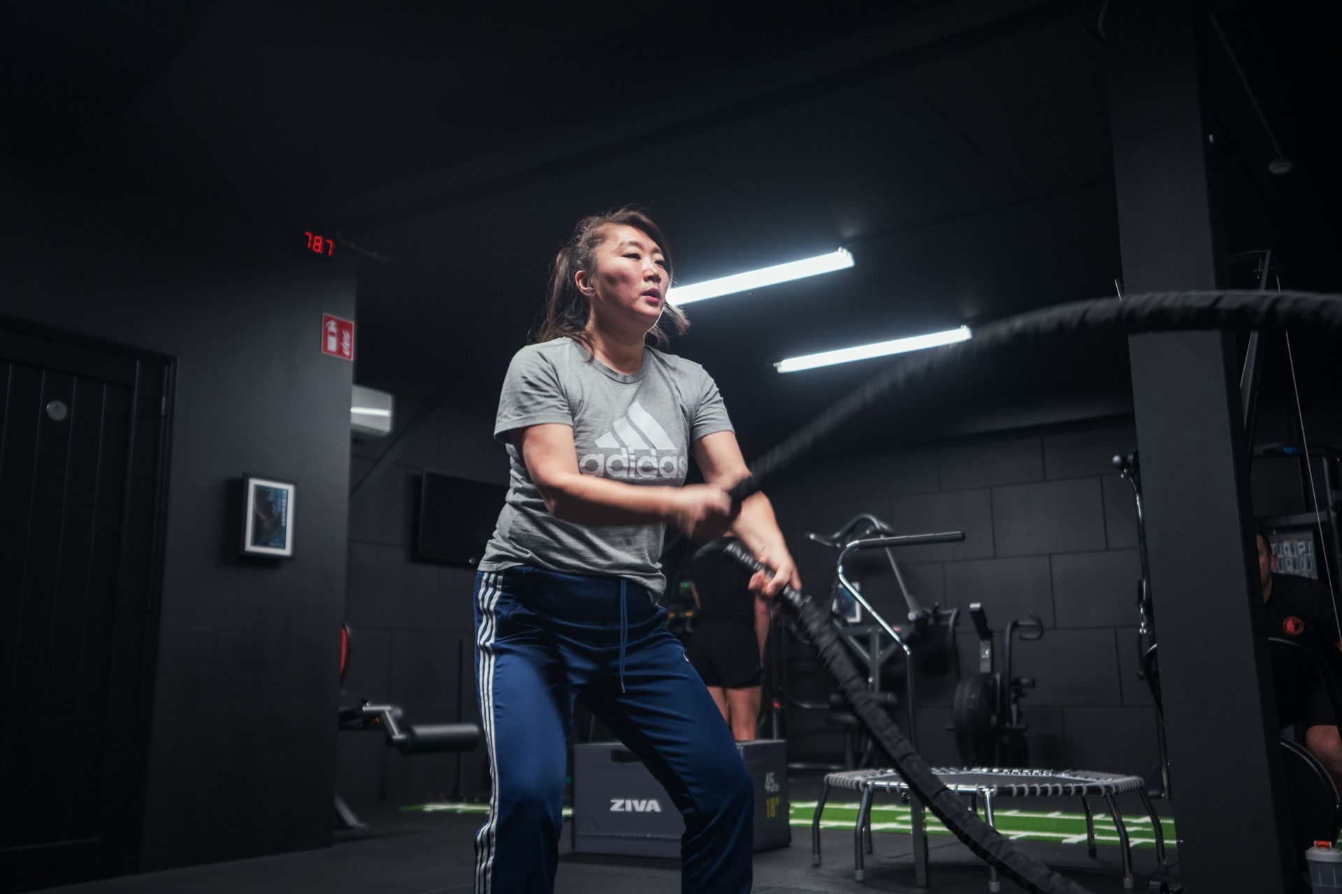Een vrouw doet een cardio oefening met een touw in een personal training studio.