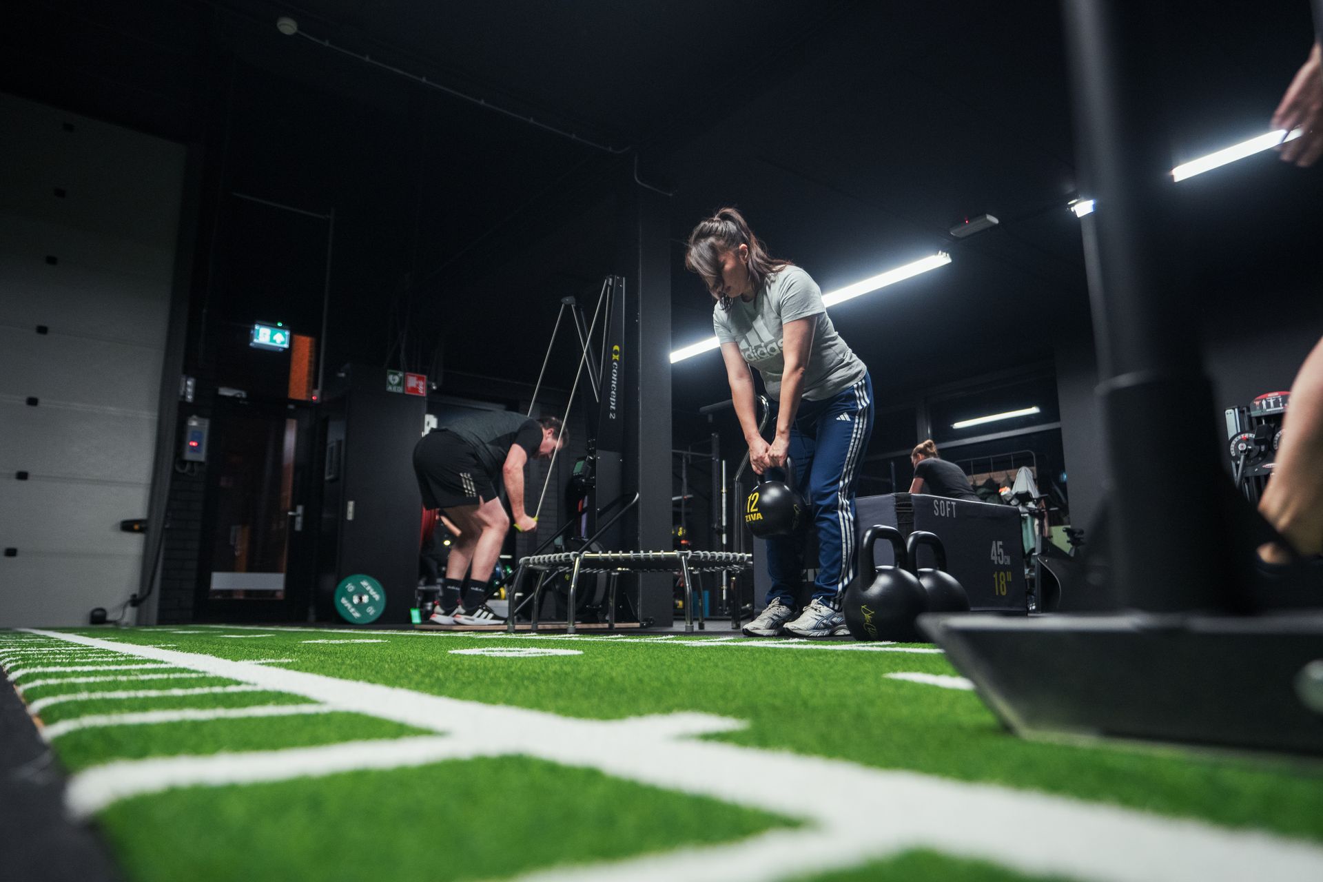 Een vrouw tilt een kettlebell op in een personal training studio.