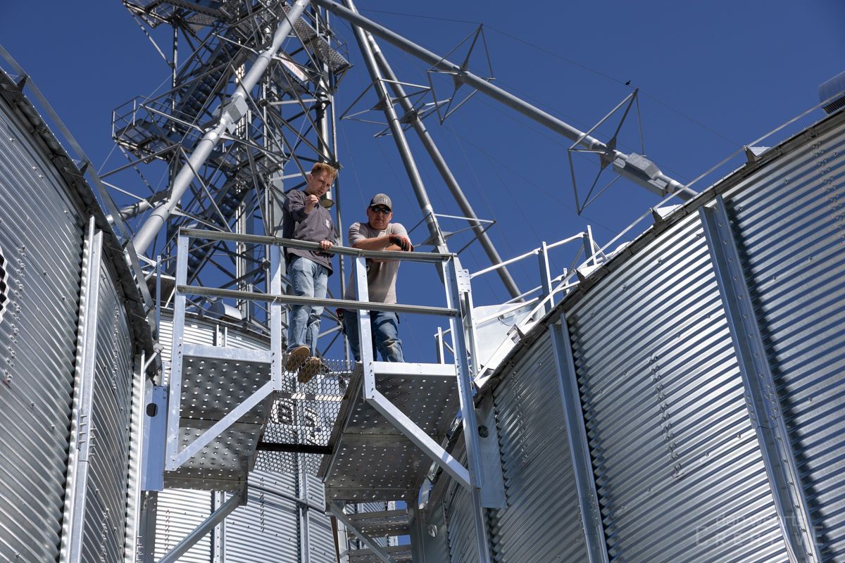 Two men are standing on top of a metal structure
