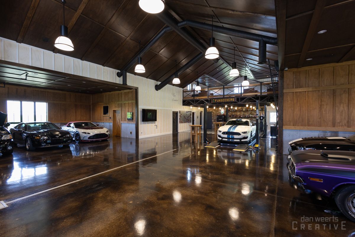 A garage filled with cars and a motorcycle.