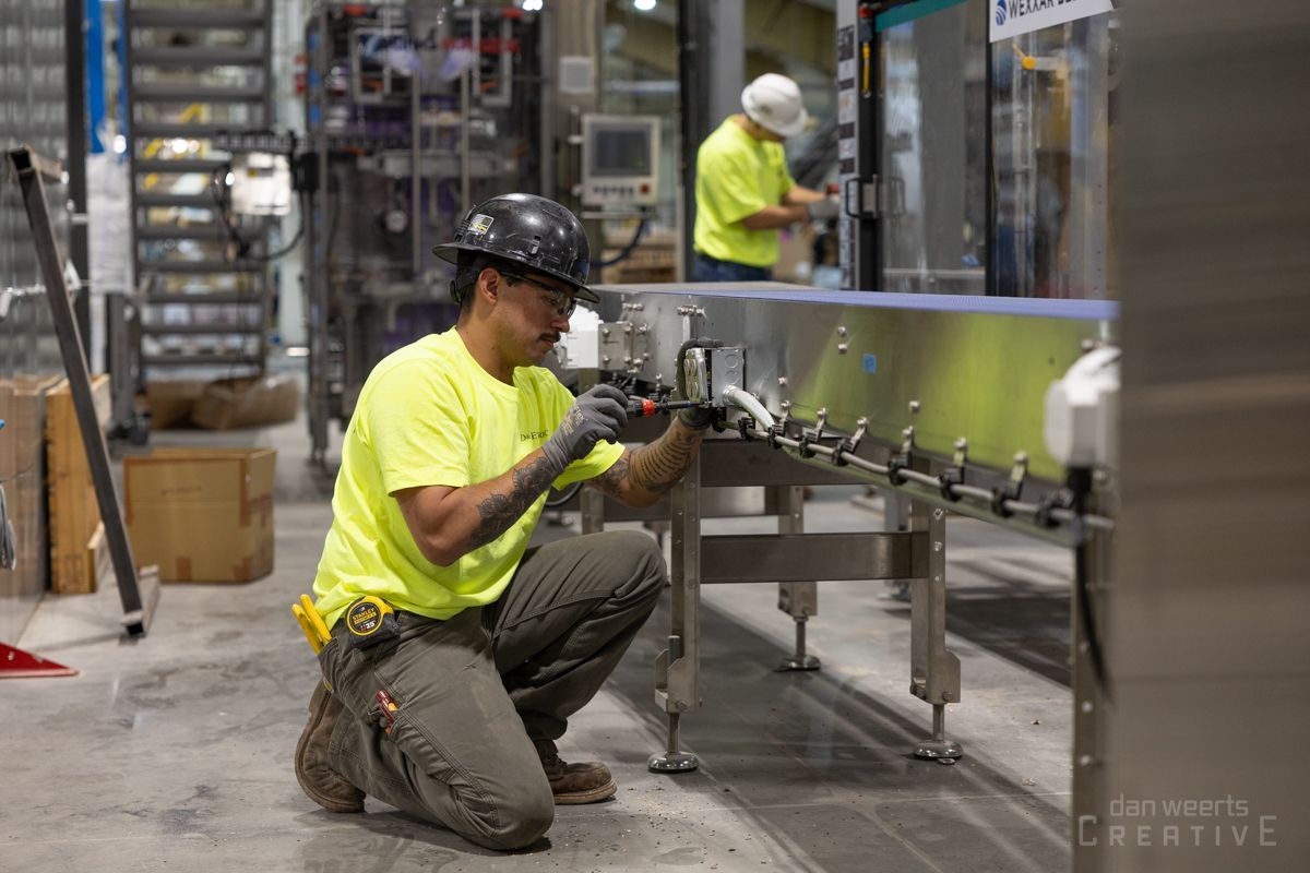 A man is working on a conveyor belt in a factory.