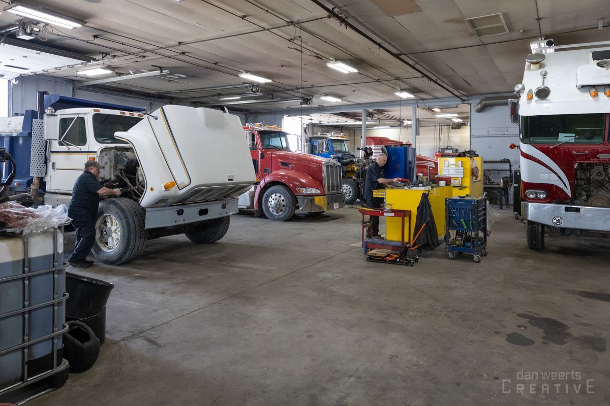 A man is working on a truck in a garage.