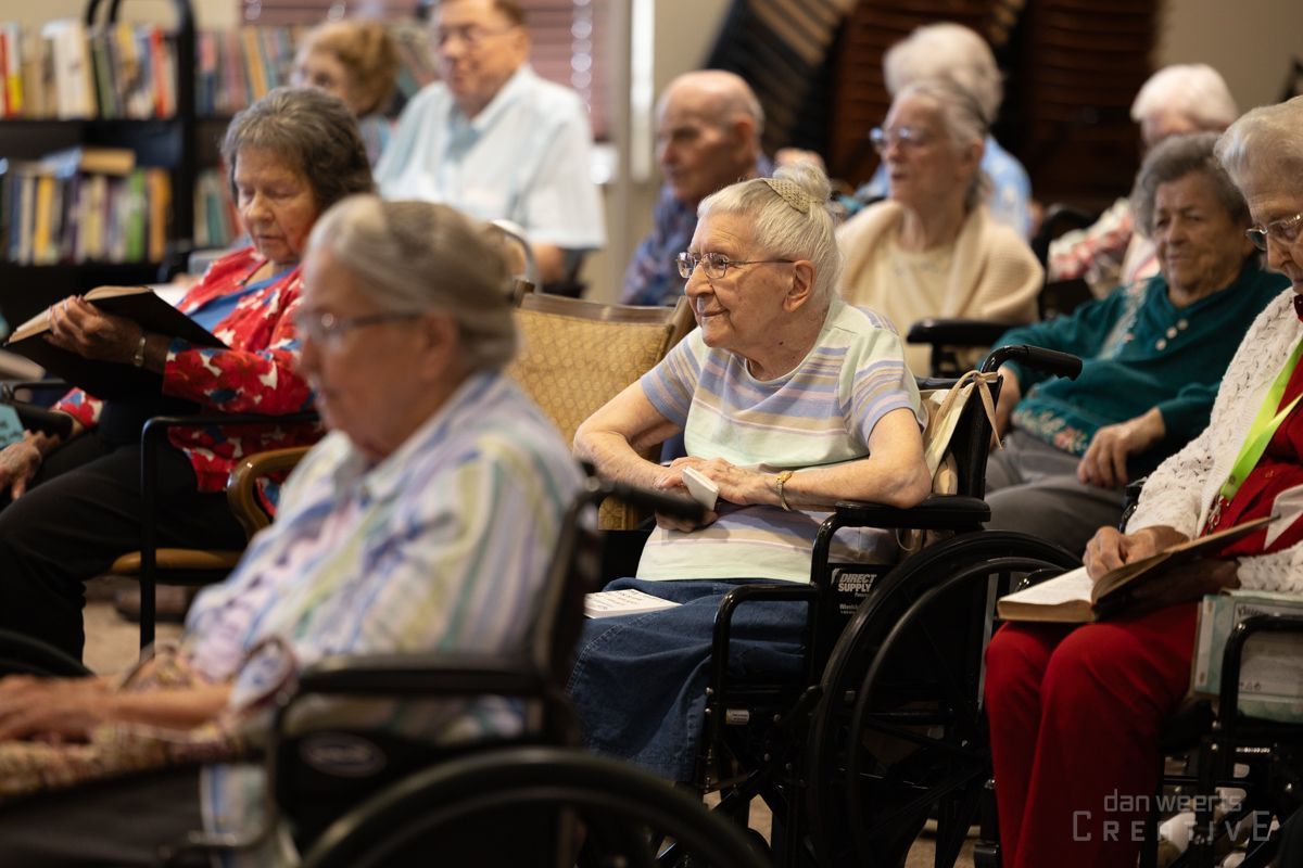 A group of elderly people in wheelchairs are sitting in a room.