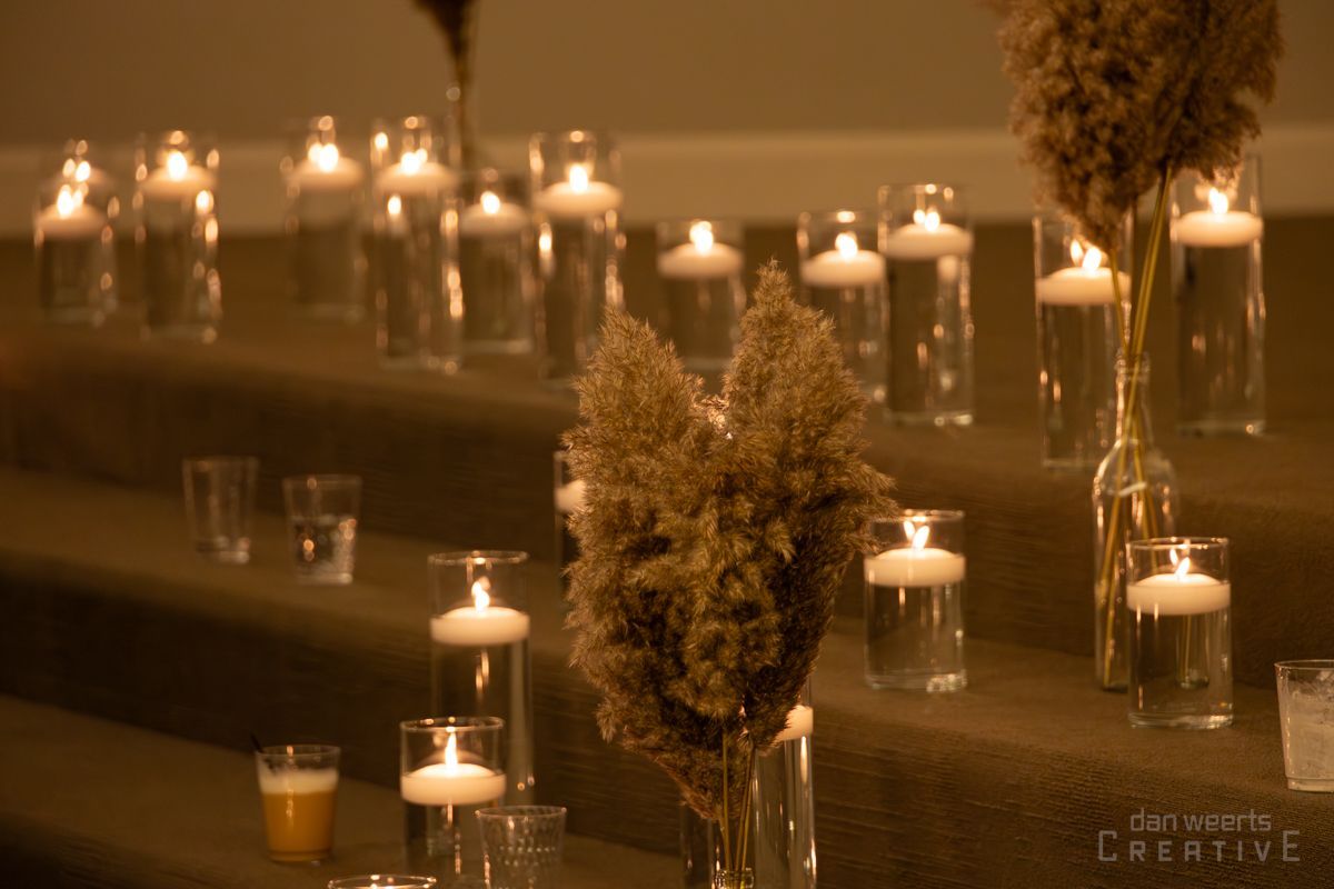 A table topped with candles and vases of flowers.