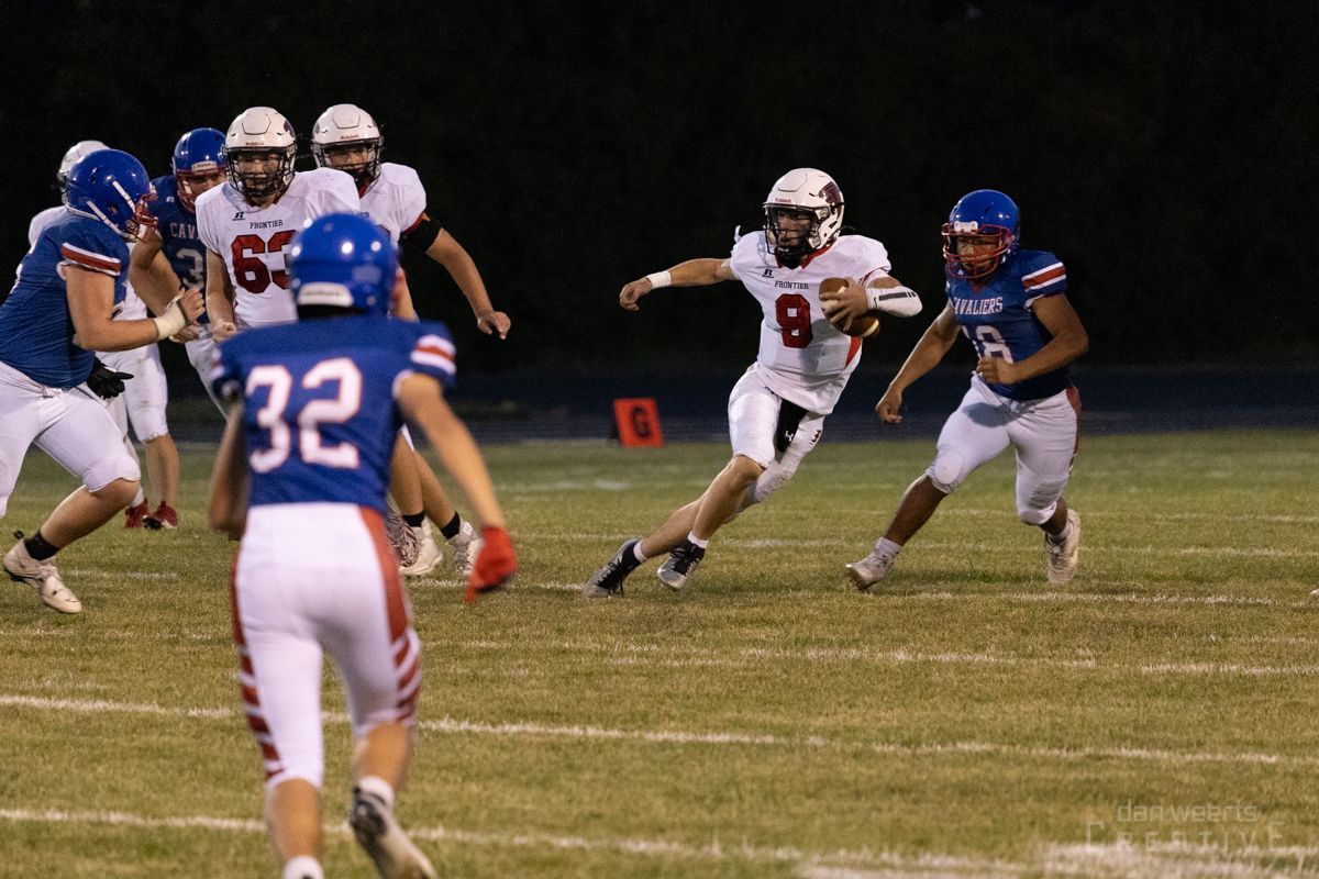 A group of football players are playing a game on a field.