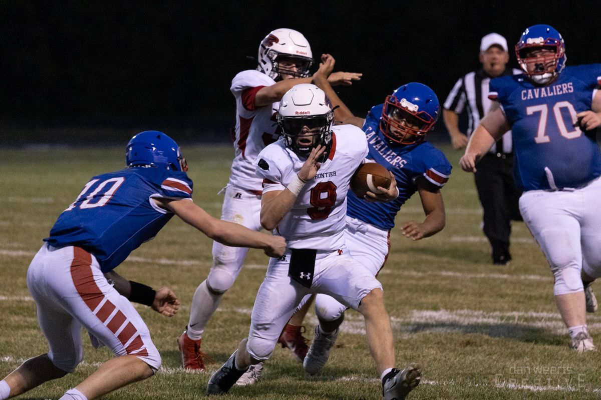 A group of football players are playing a game on a field.